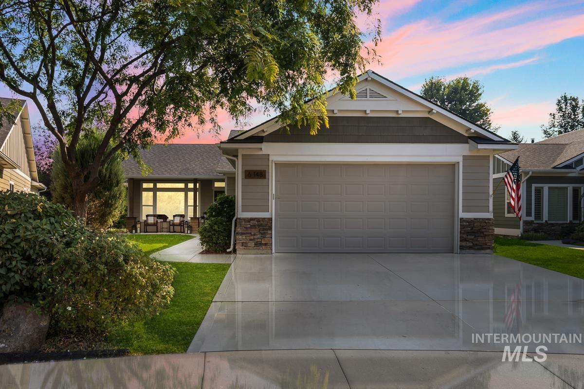Craftsman inspired home with stone siding, concrete driveway, and a garage
