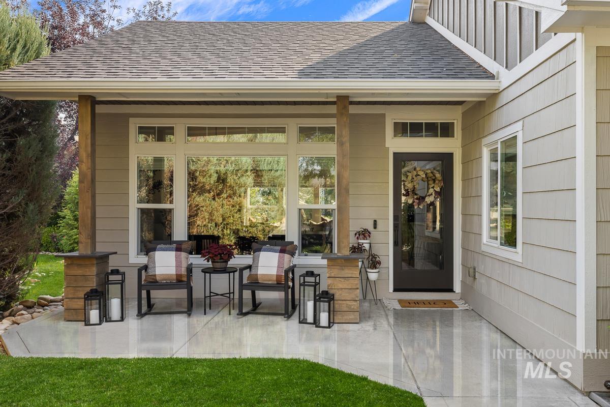Doorway to property featuring a shingled roof and a patio area
