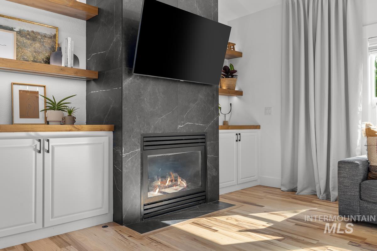 Detailed view of wood finished floors and a fireplace