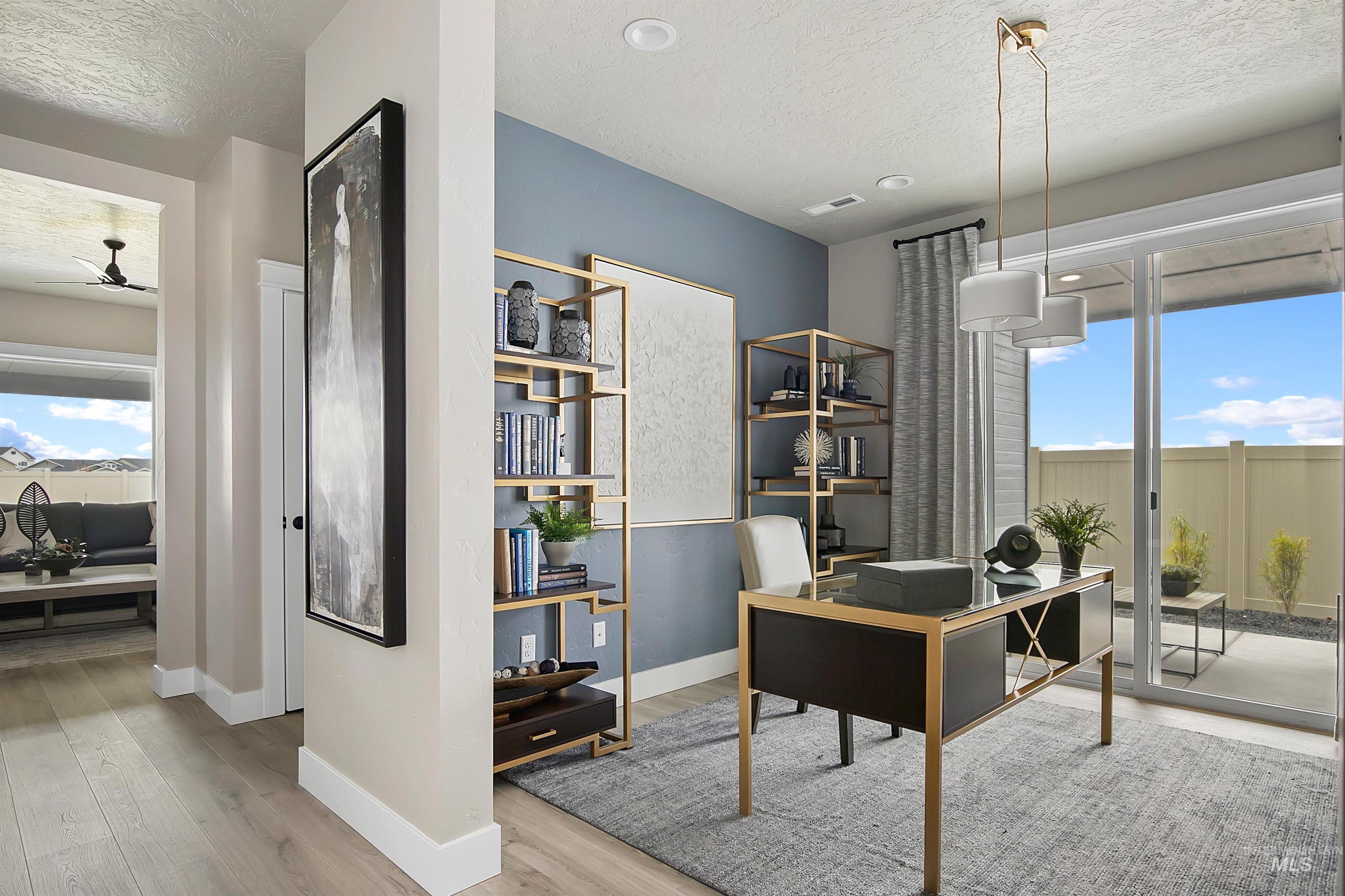 Office with a textured ceiling, light wood-type flooring, and ceiling fan