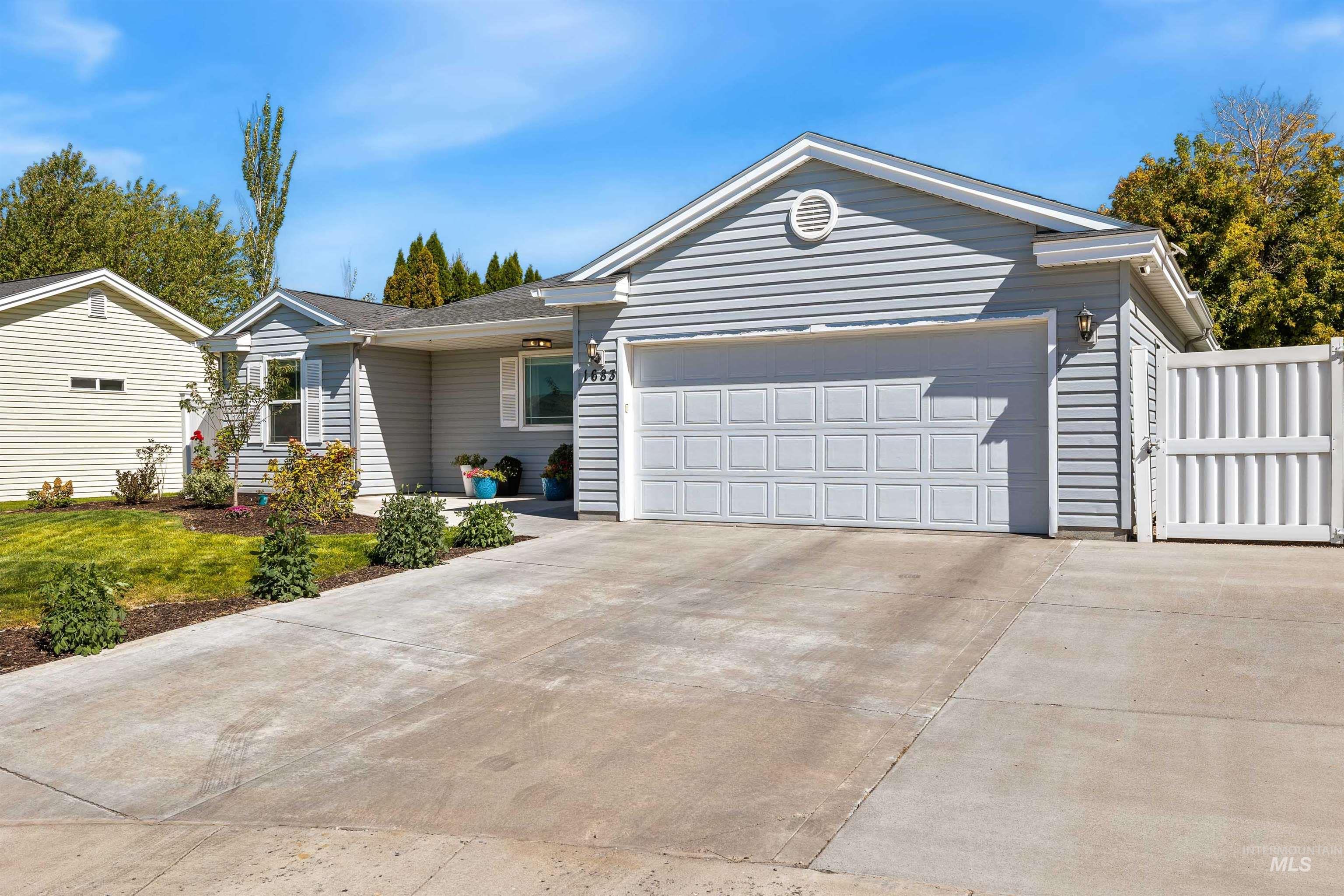 Ranch-style house featuring driveway and an attached garage