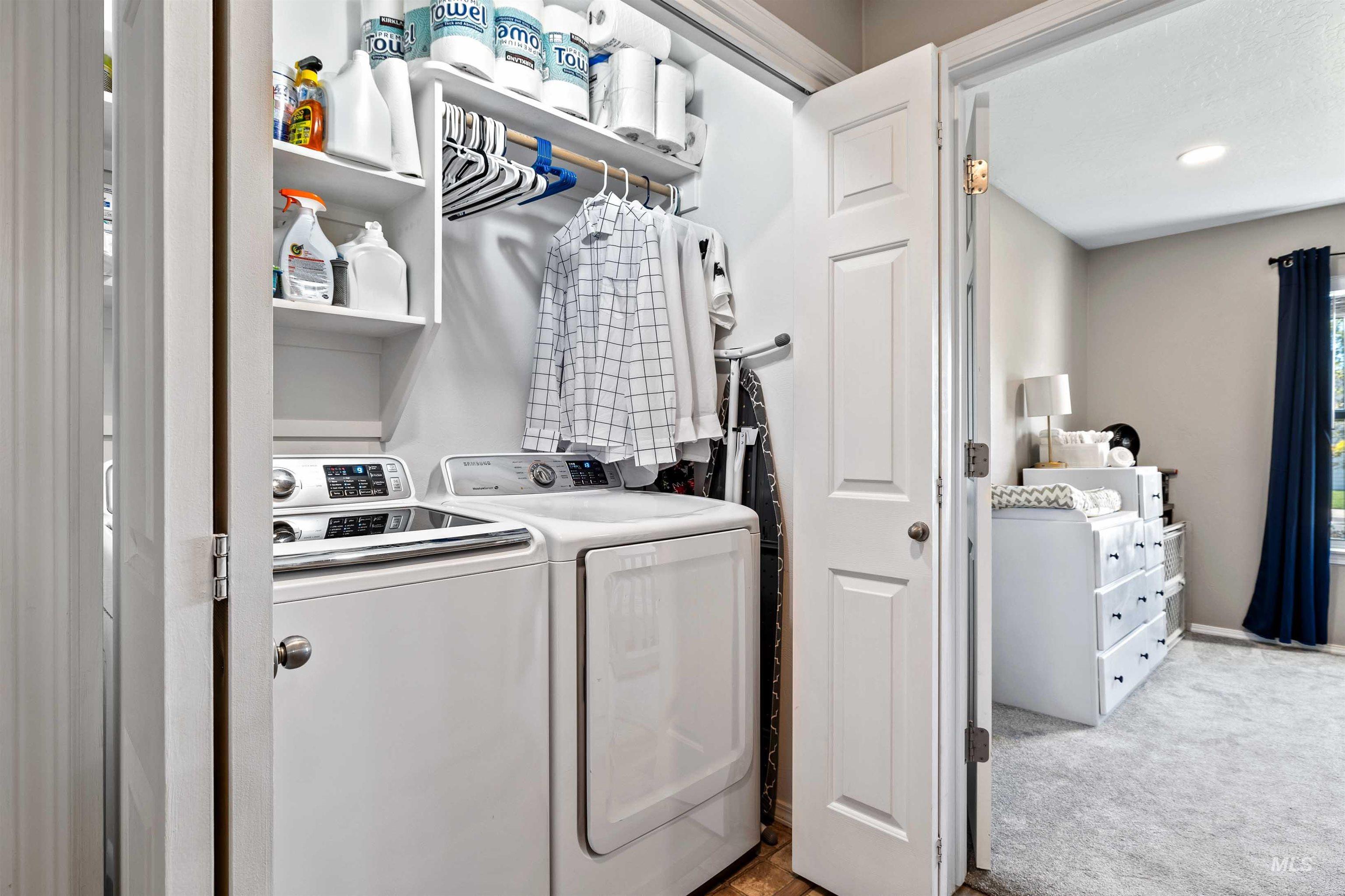 Laundry area featuring light colored carpet and washing machine and dryer