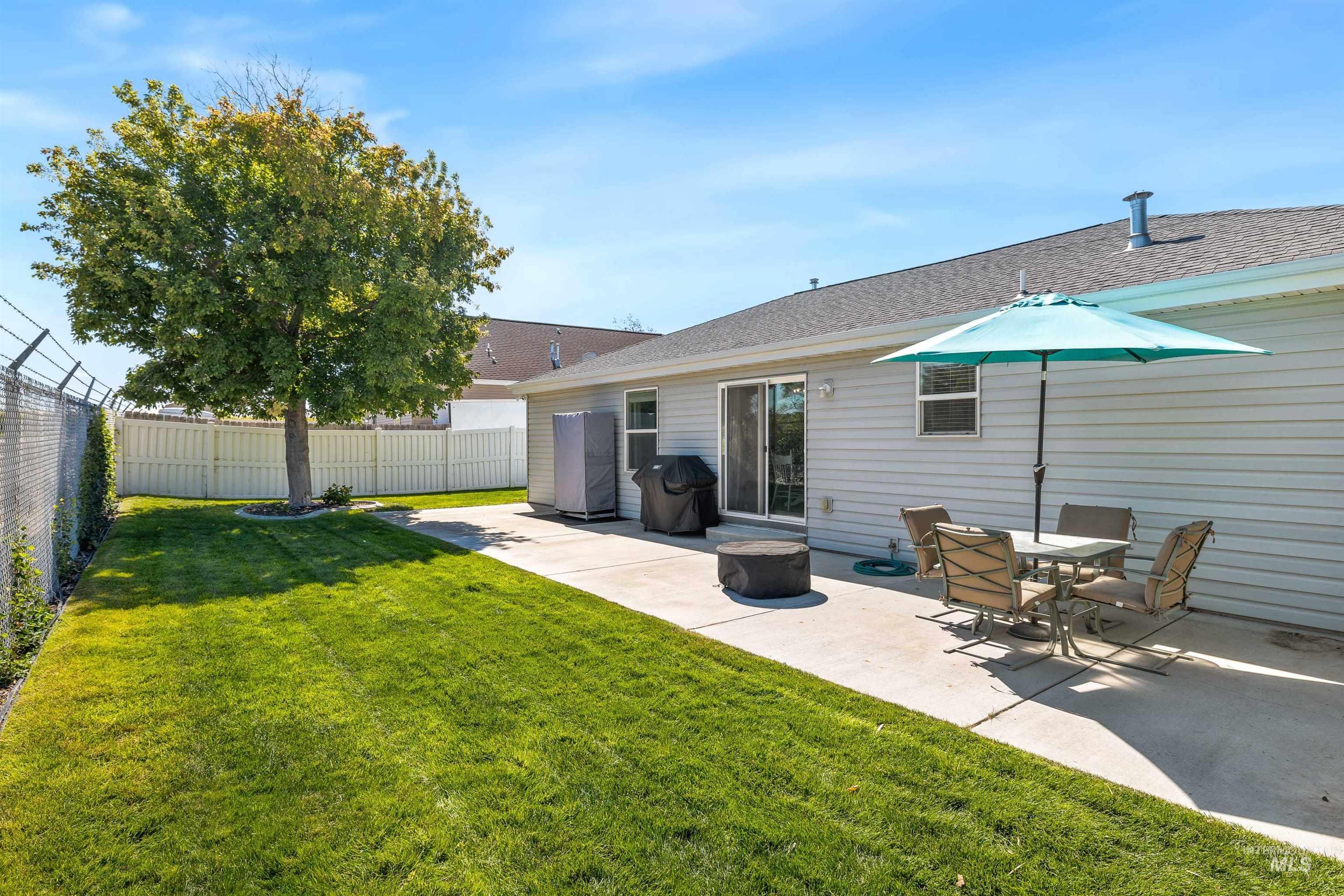 Back of house featuring a patio area and roof with shingles