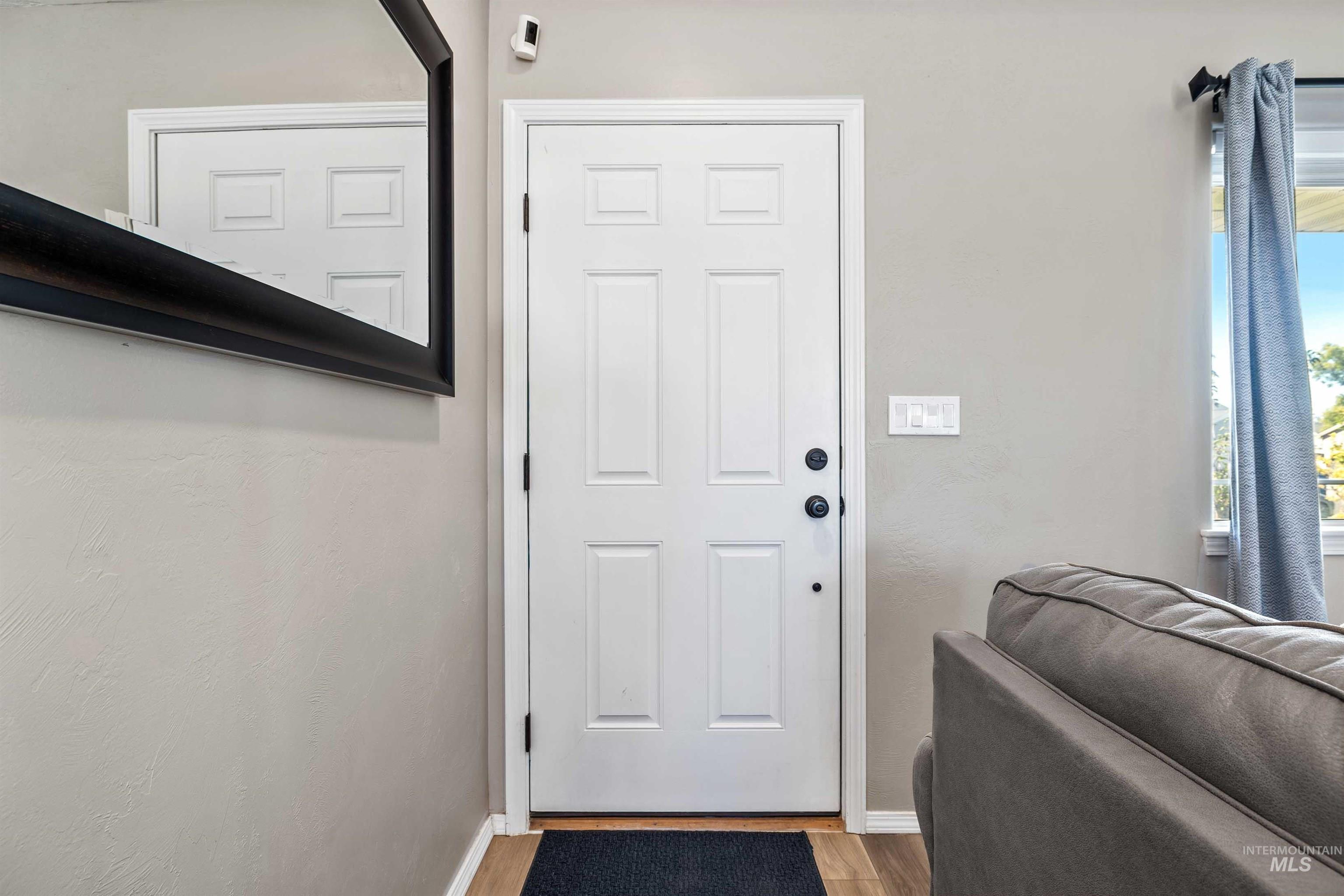 Doorway to outside featuring wood finished floors and baseboards