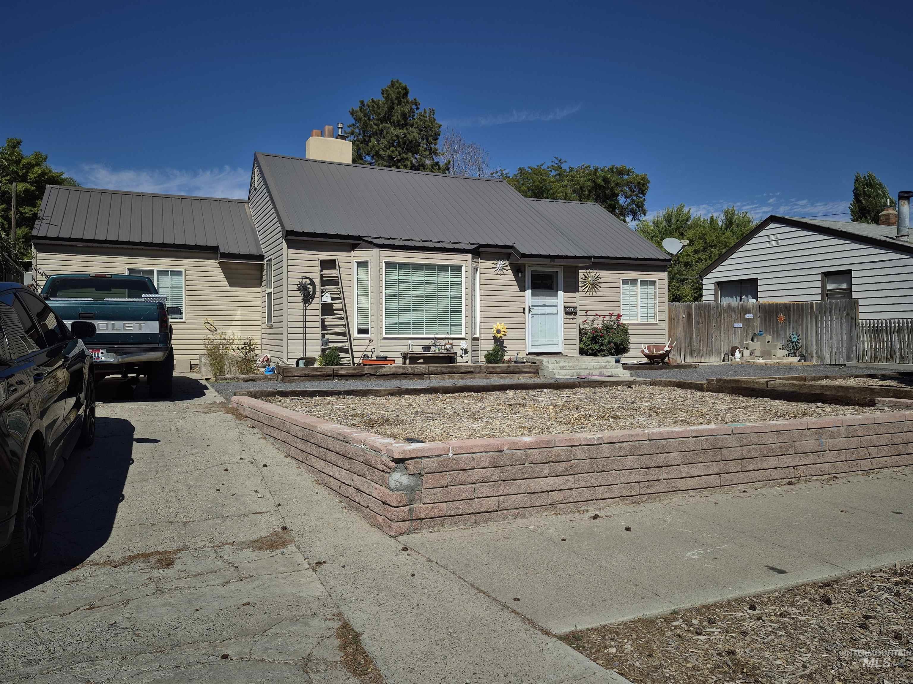 Ranch-style house with a metal roof and a chimney