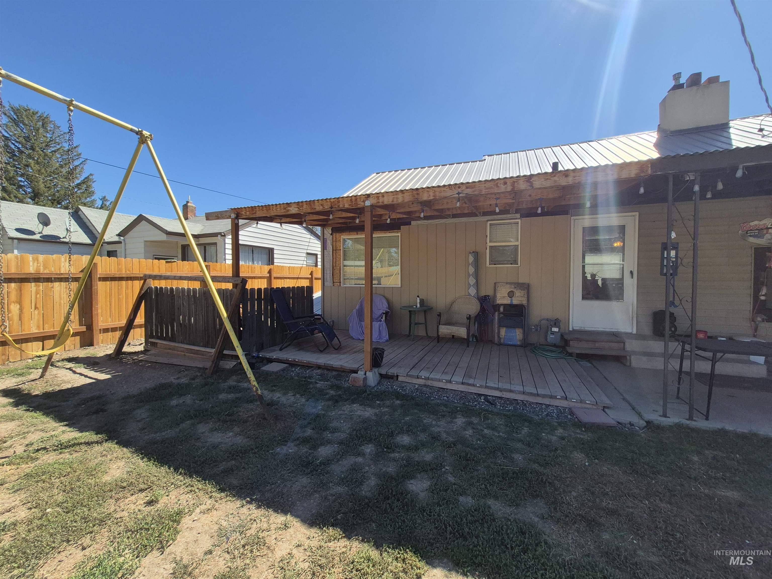 Rear view of house with a wooden deck and a metal roof