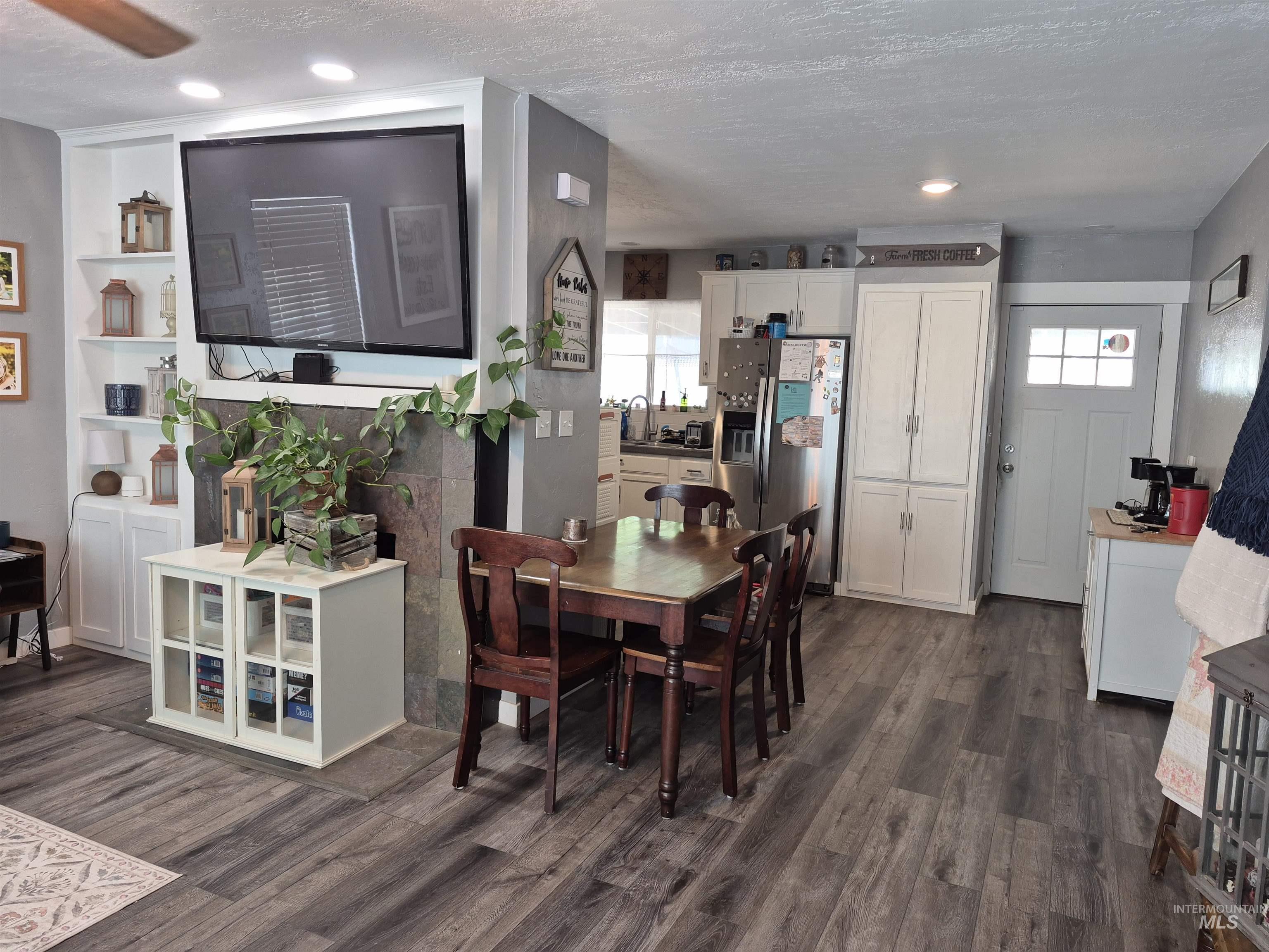Dining room featuring a textured ceiling, dark wood-style floors, healthy amount of natural light, and recessed lighting
