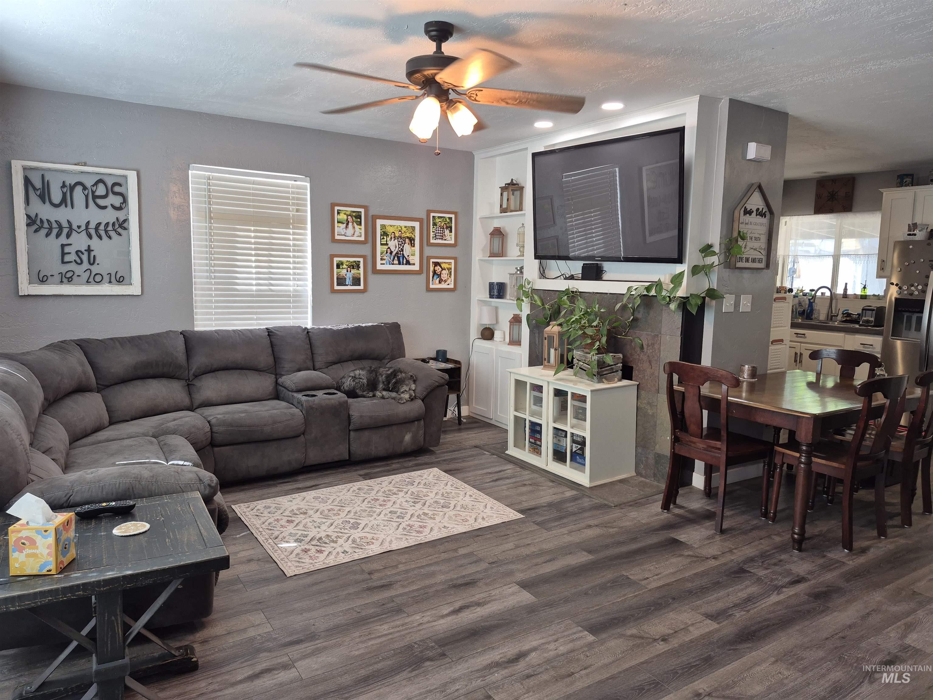 Living room featuring a textured ceiling, dark wood-style floors, ceiling fan, built in features, and recessed lighting