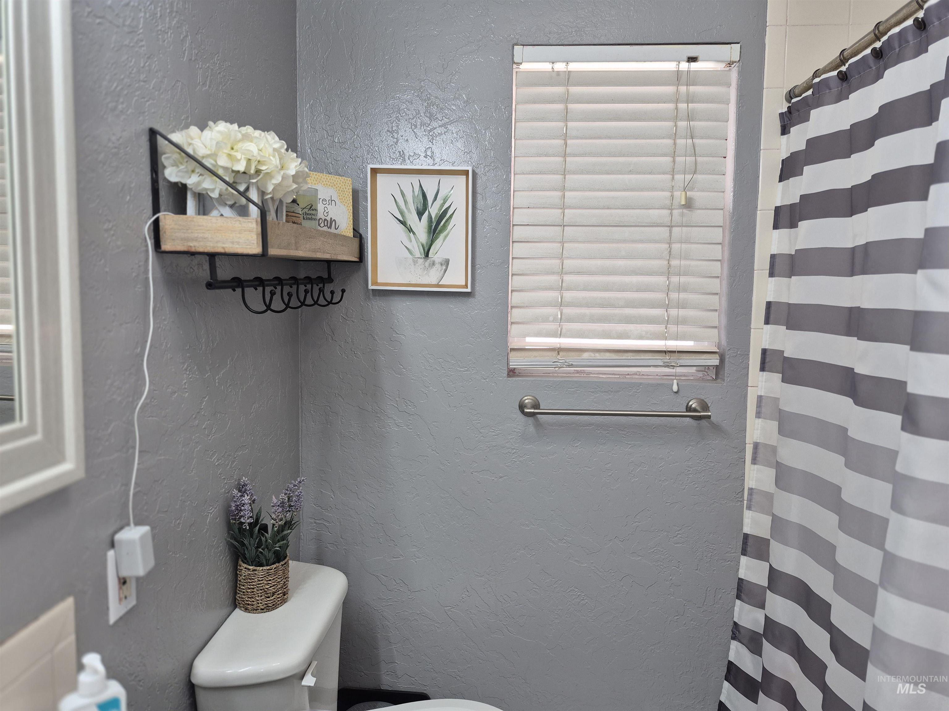 Full bath with a textured wall and curtained shower