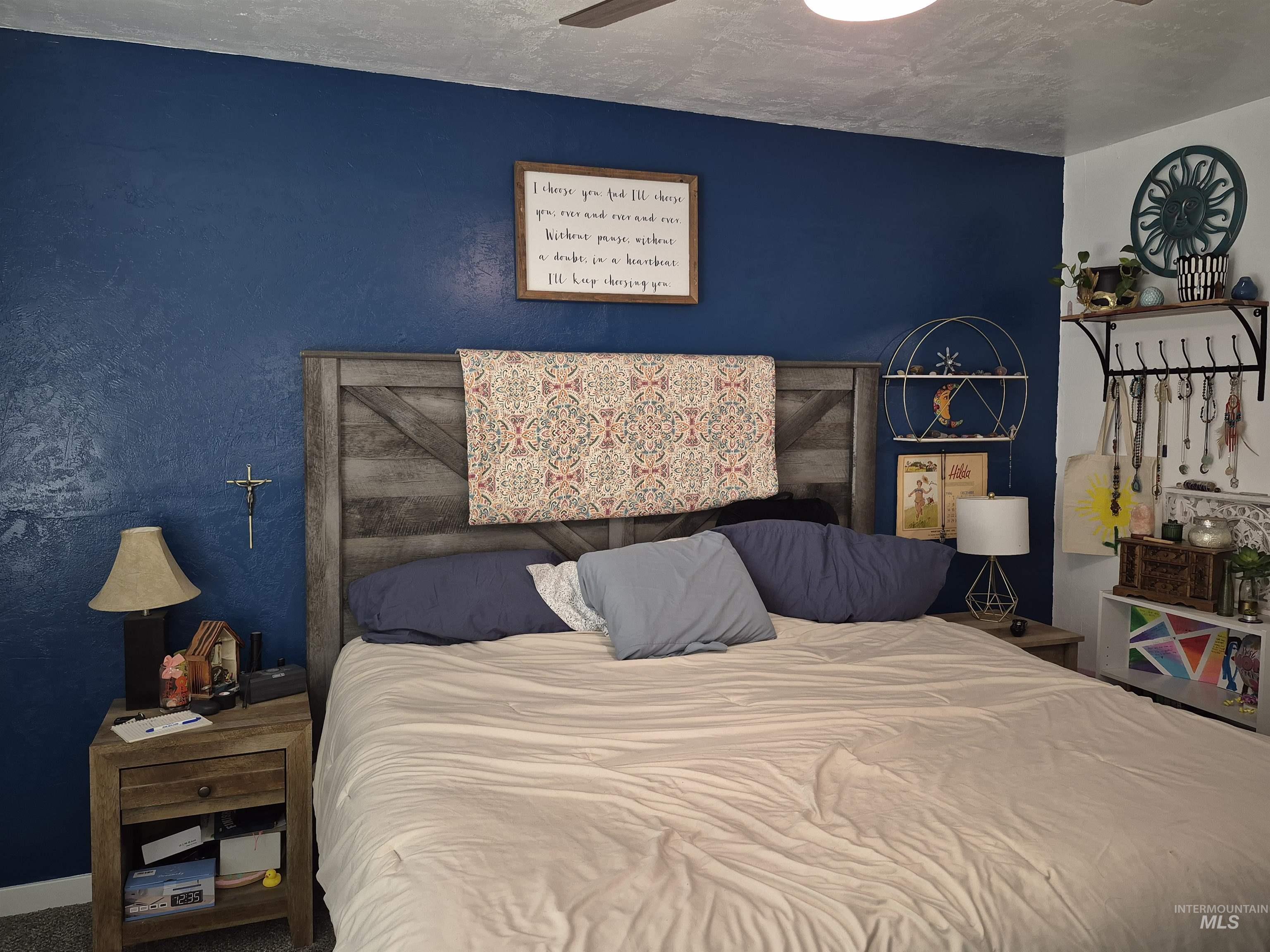 Bedroom featuring a textured wall and a ceiling fan