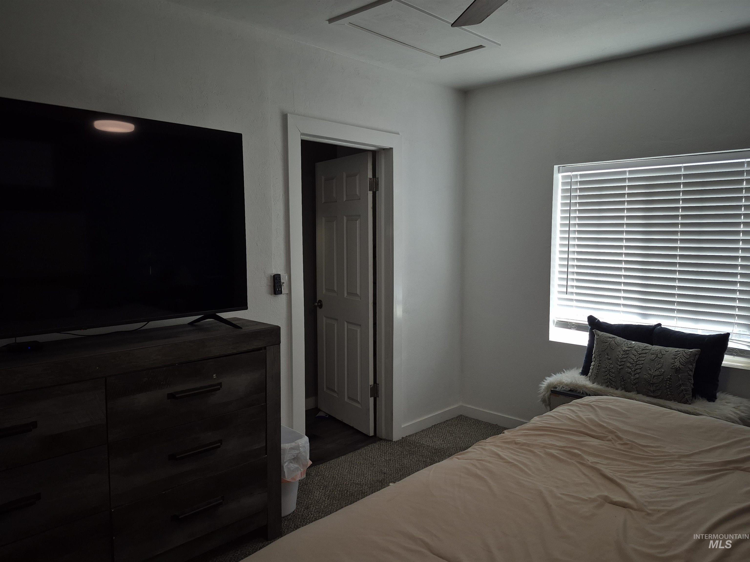 Bedroom featuring dark colored carpet and baseboards