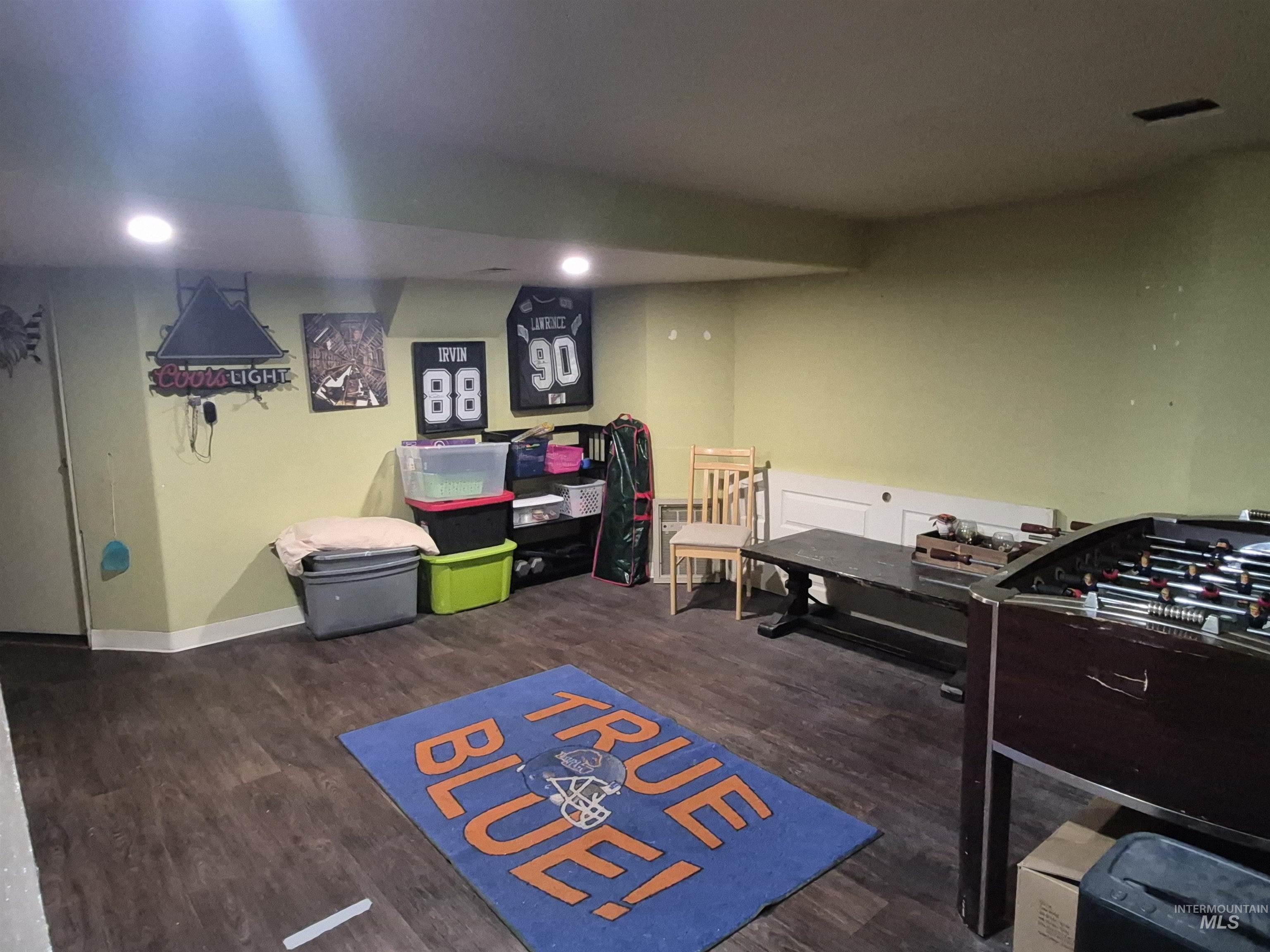 Rec room featuring dark wood-type flooring and baseboards