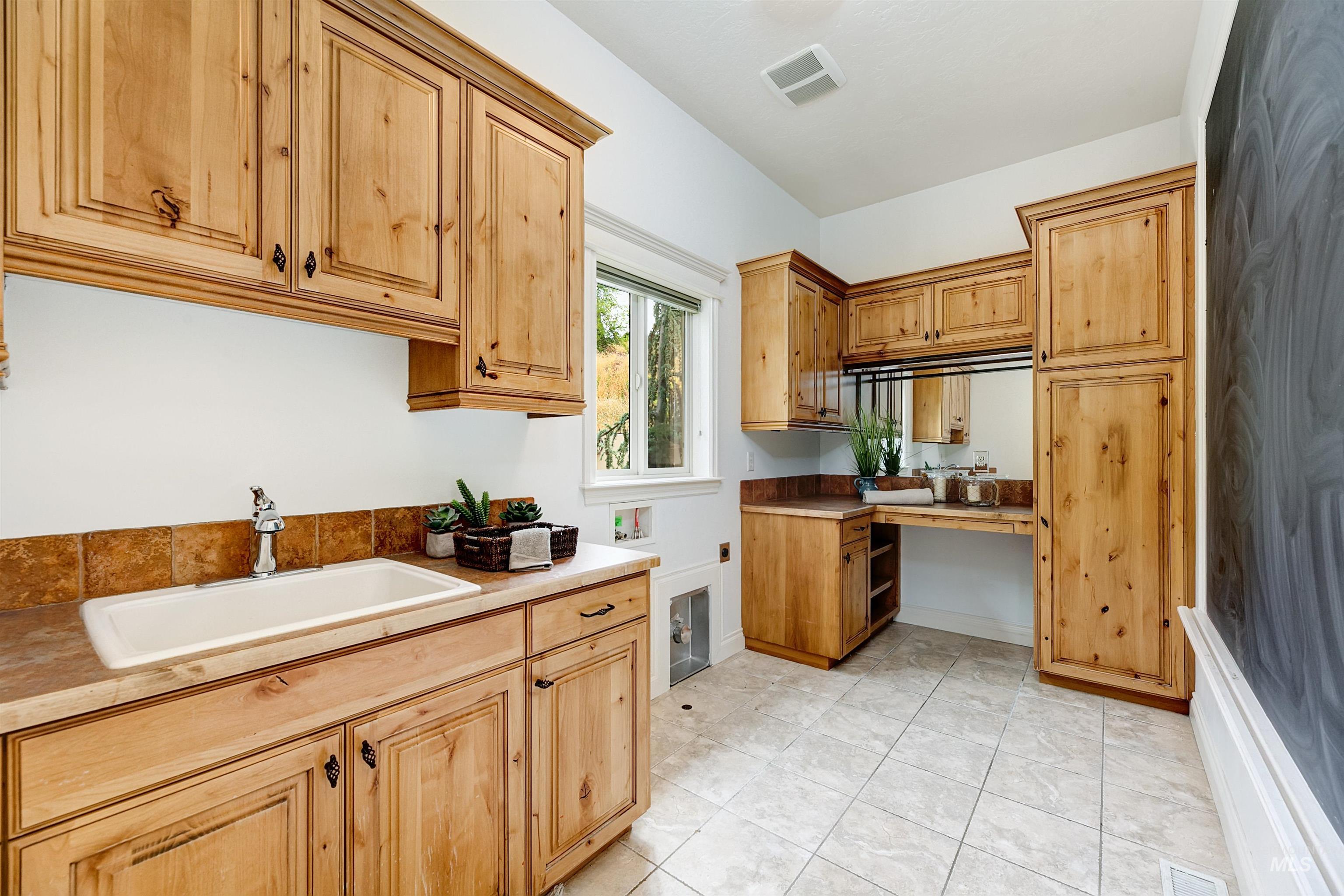 Kitchen with light tile patterned flooring and light countertops