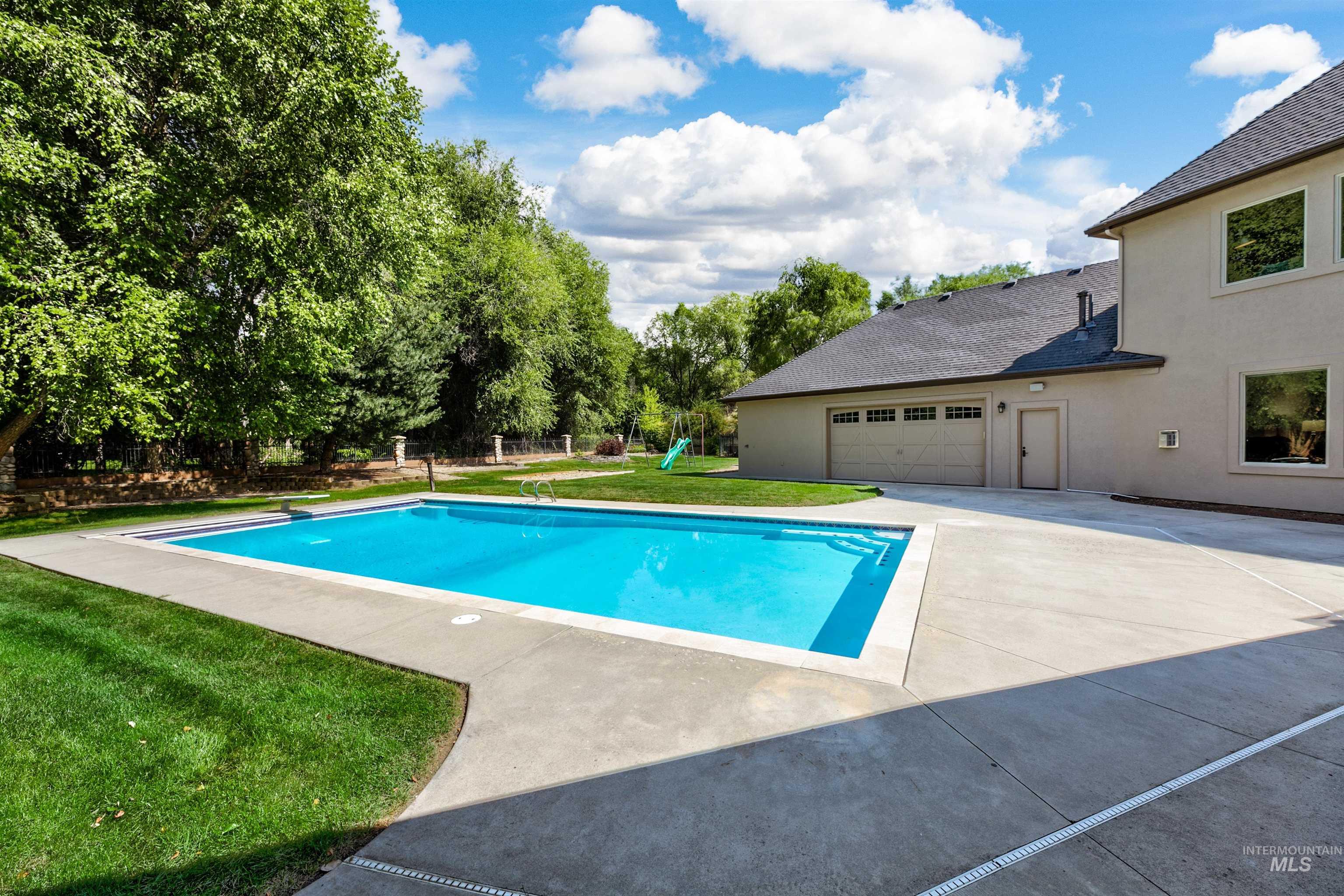 View of swimming pool with a yard, a diving board, and a playground