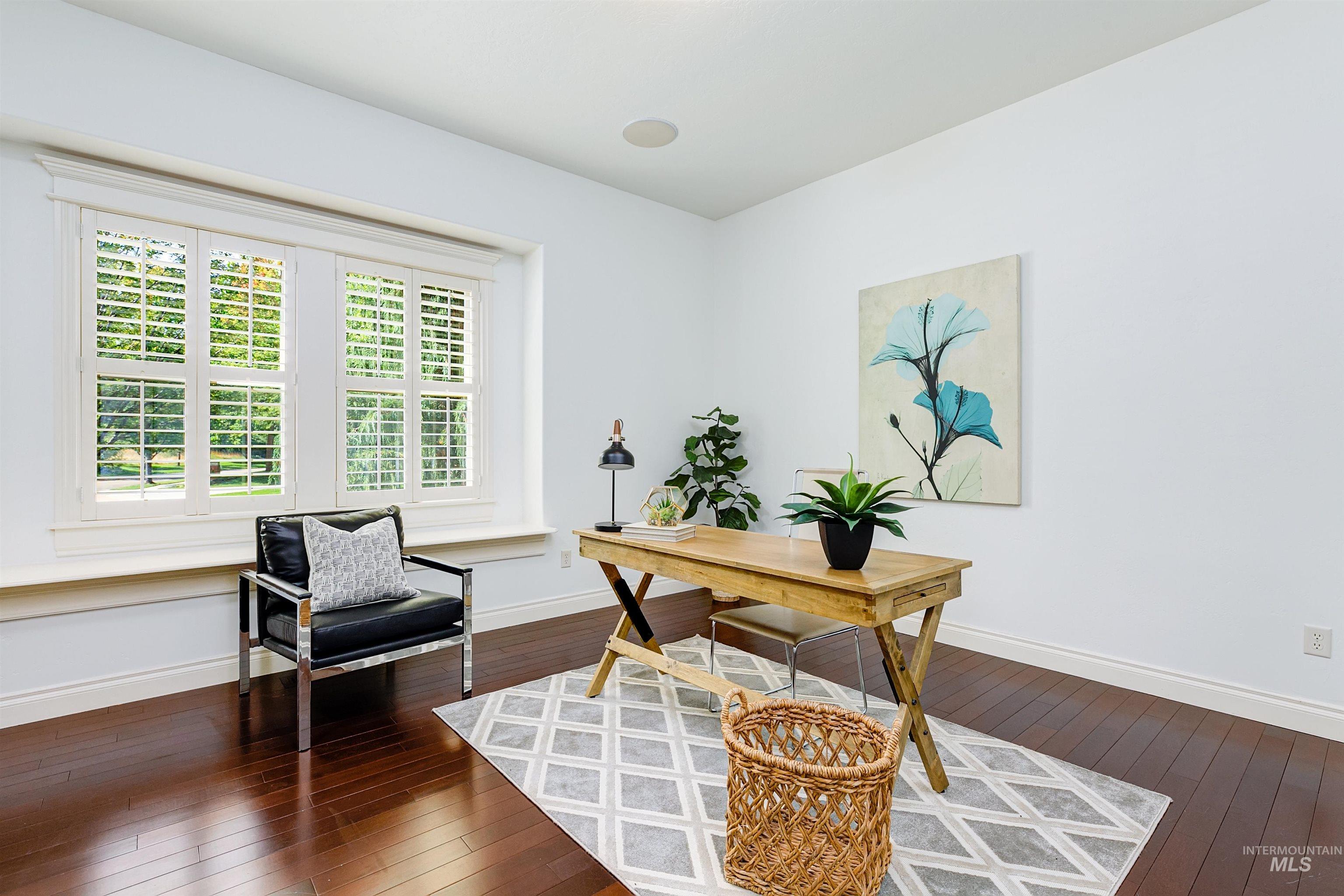 Office area with dark wood-type flooring and baseboards