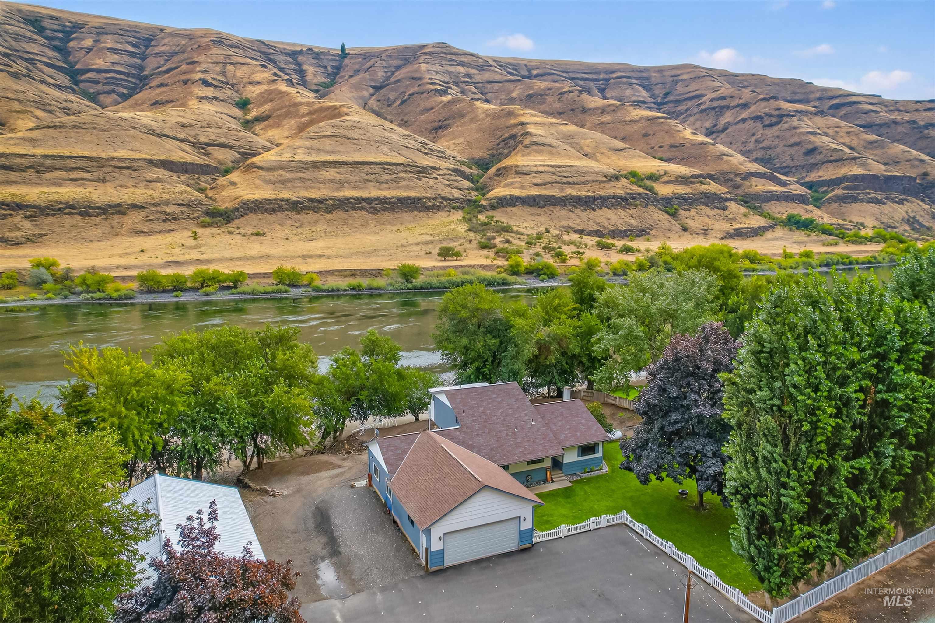 Aerial view of property and surrounding area with a water and mountain view