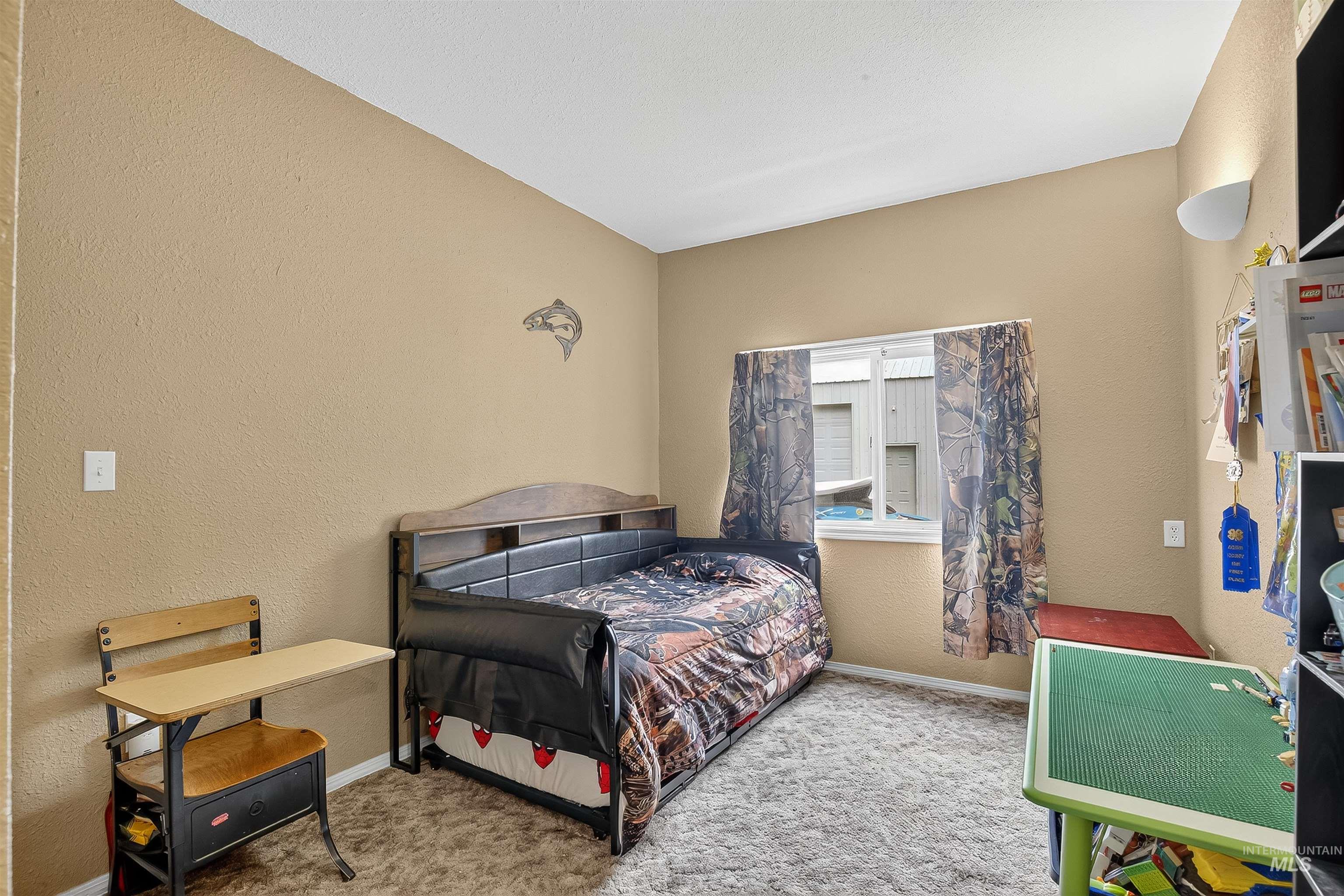 Bedroom with a textured wall and light colored carpet