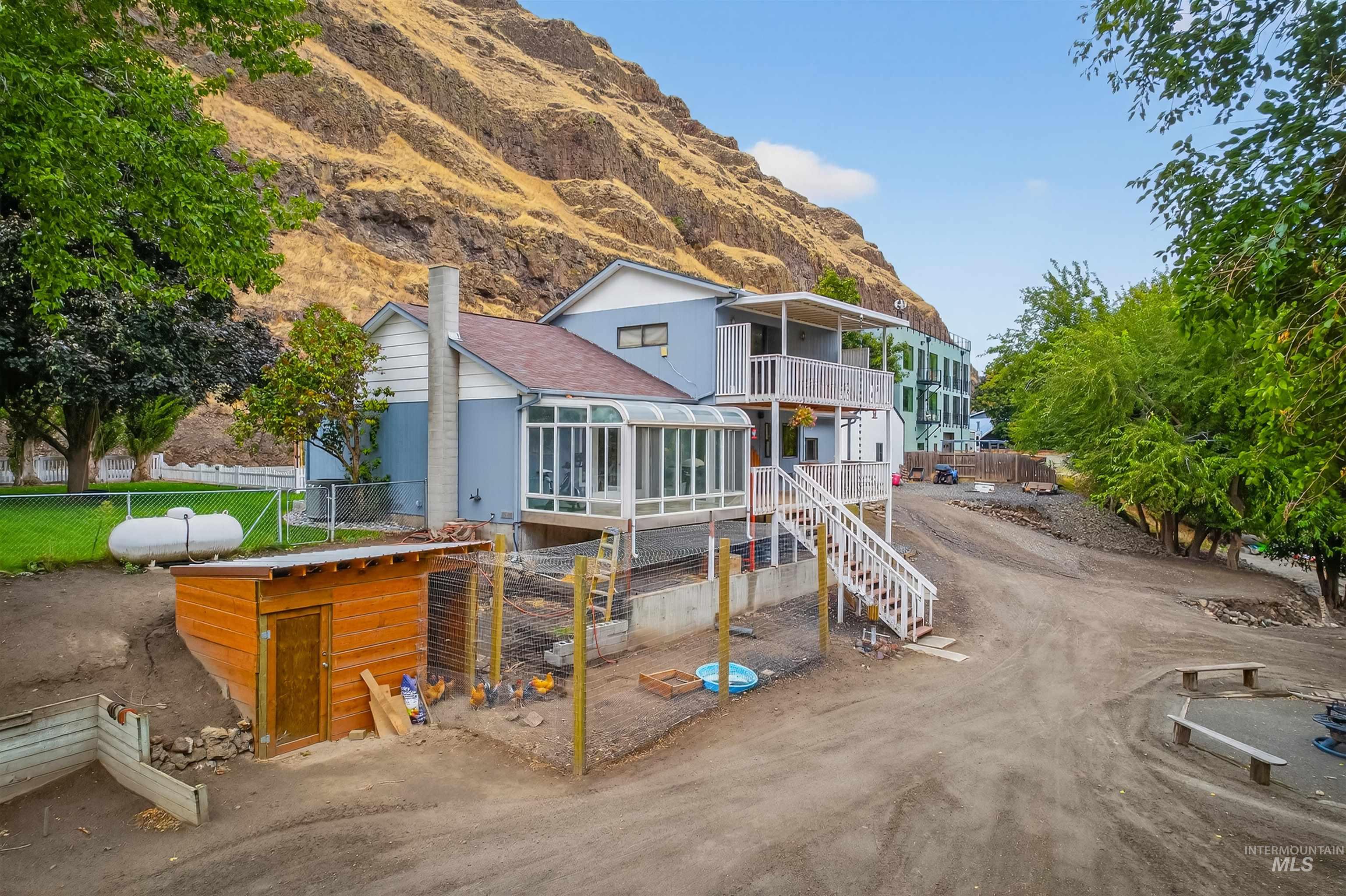 Rear view of house with a balcony, a mountain view, and stairway