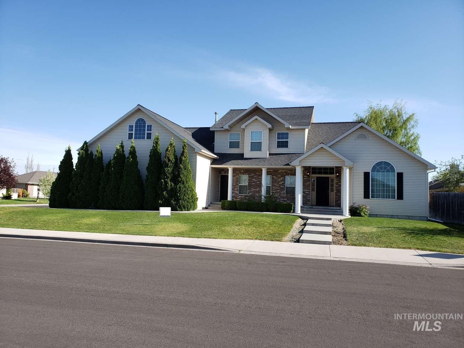 View of front of property featuring a front lawn, a porch, and a shingled roof