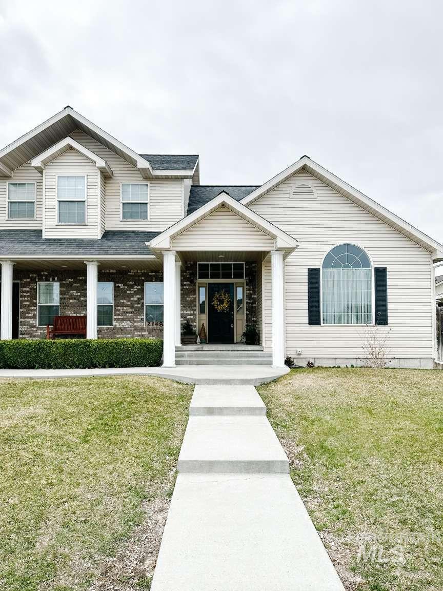 View of front facade with a front yard and a porch