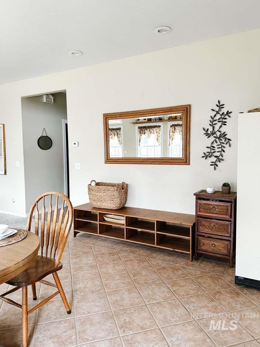 Living area with light tile patterned floors and recessed lighting