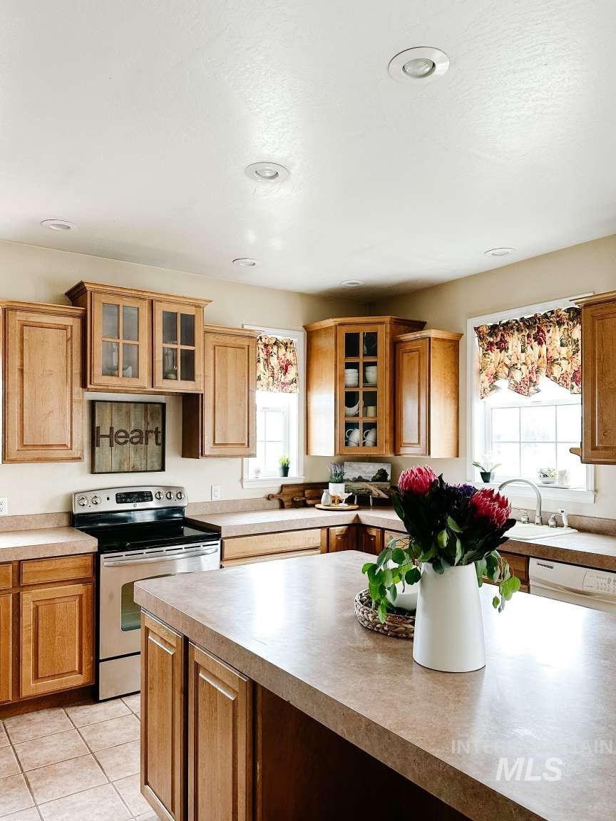 Kitchen featuring electric range, glass insert cabinets, and plenty of natural light