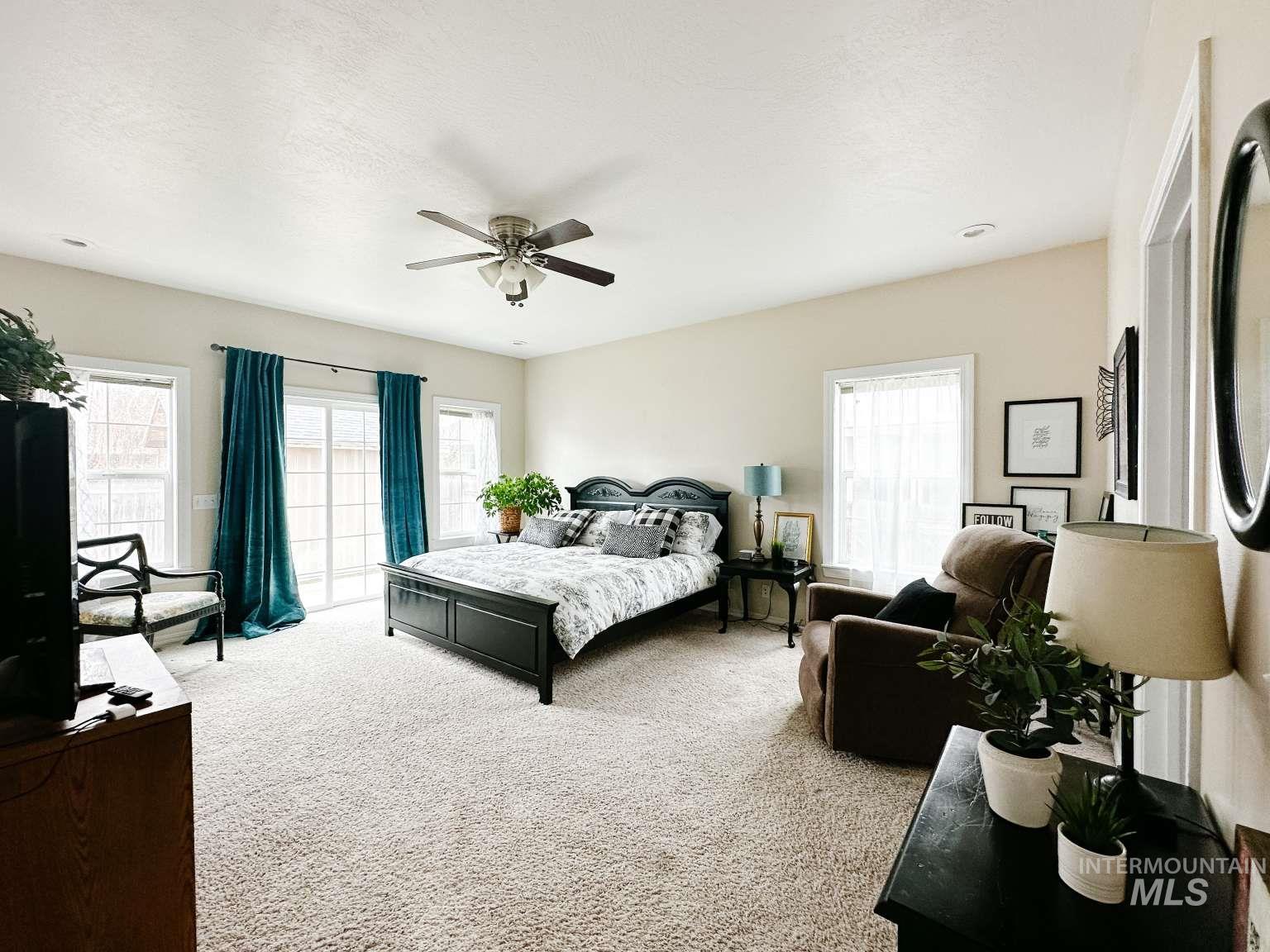 Bedroom with carpet, ceiling fan, and a textured ceiling