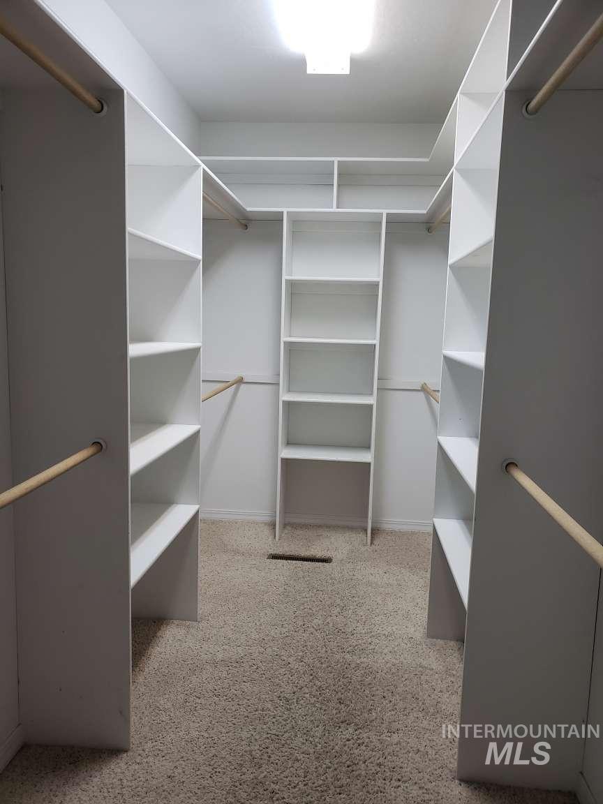 Walk in closet featuring light carpet