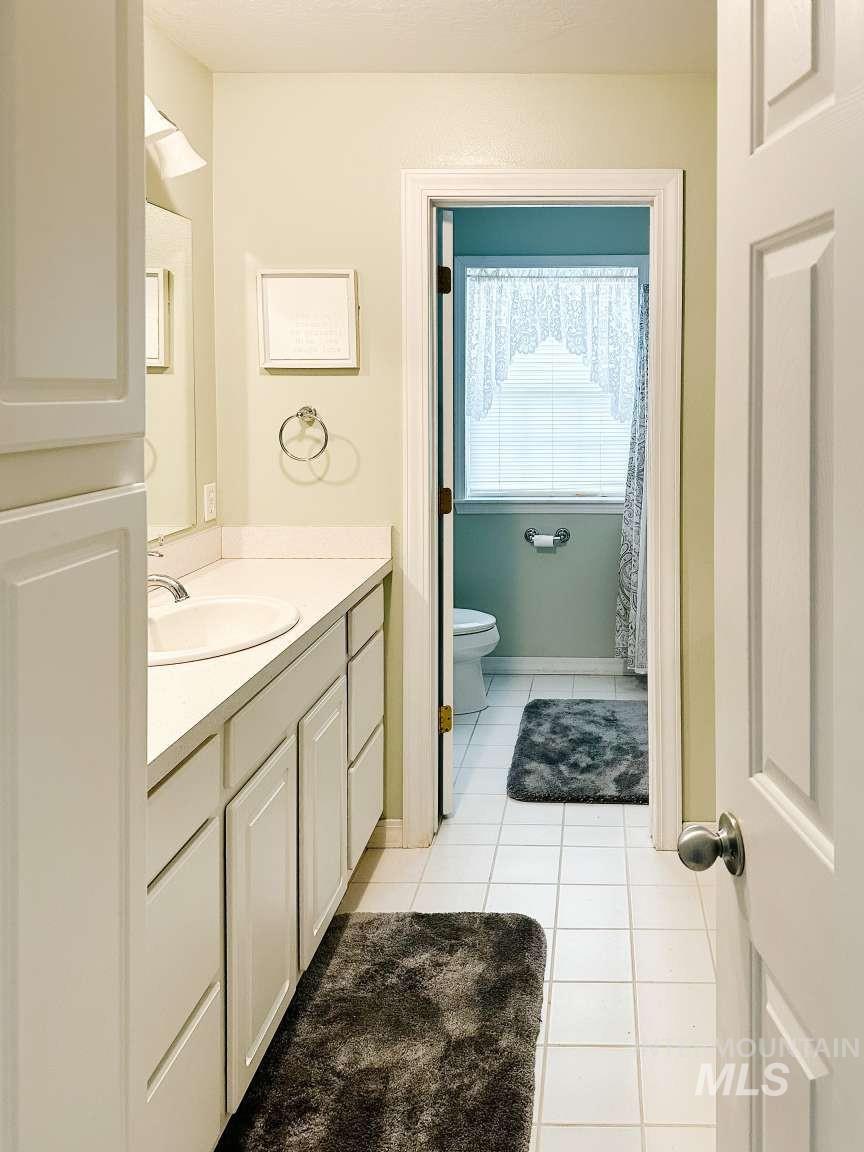 Bathroom with light tile patterned floors and vanity