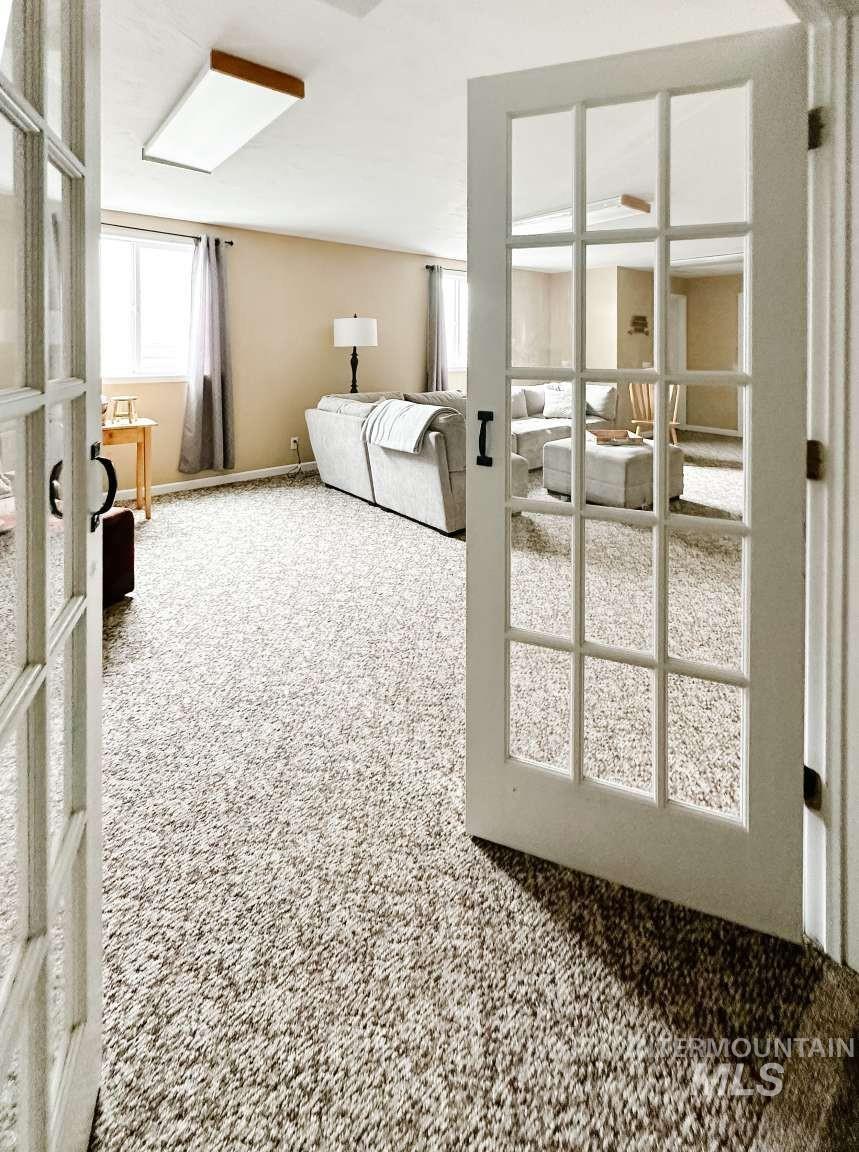 Carpeted living room with french doors