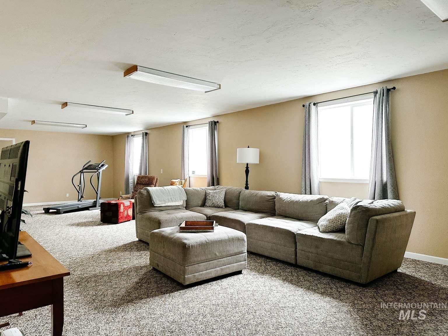 Carpeted living area featuring baseboards