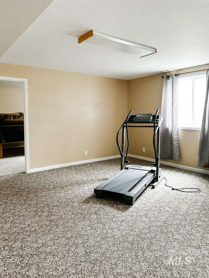 Workout room with carpet flooring and baseboards