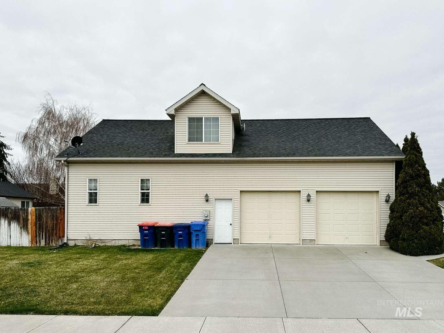 View of side of home featuring driveway, a garage, and a shingled roof