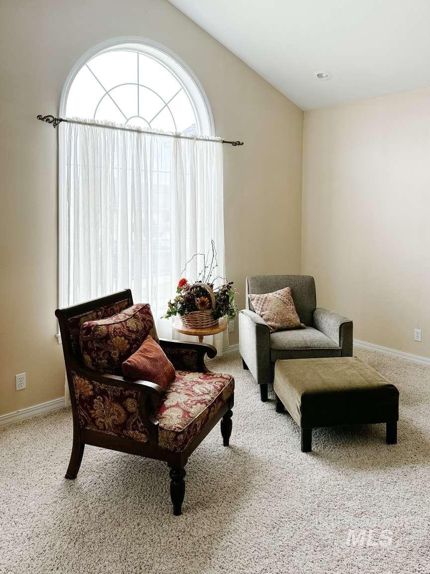 Sitting room featuring light carpet and lofted ceiling