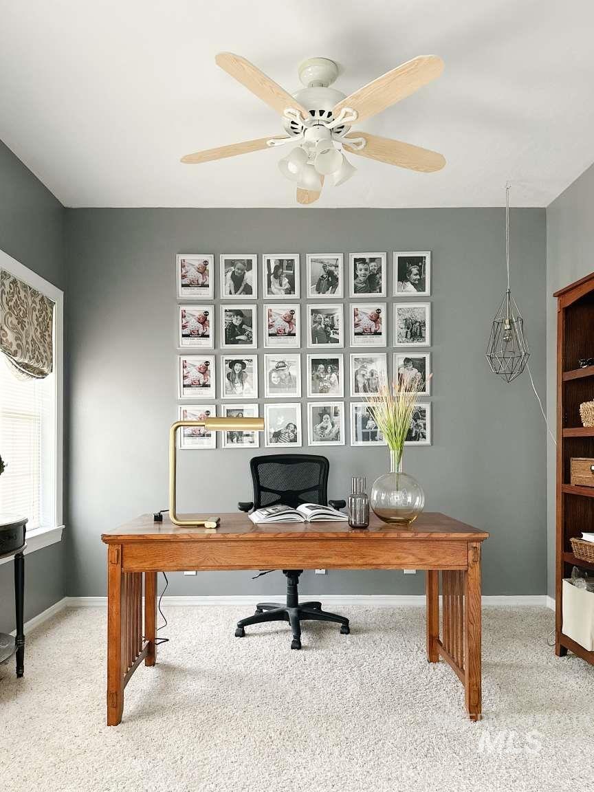 Office space with light carpet and ceiling fan