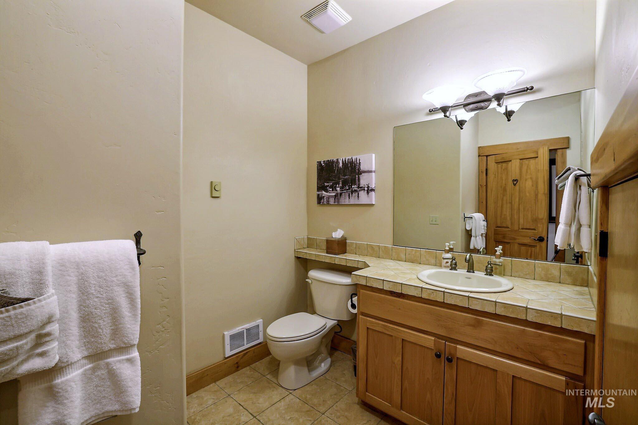 Bathroom featuring light tile patterned flooring and vanity