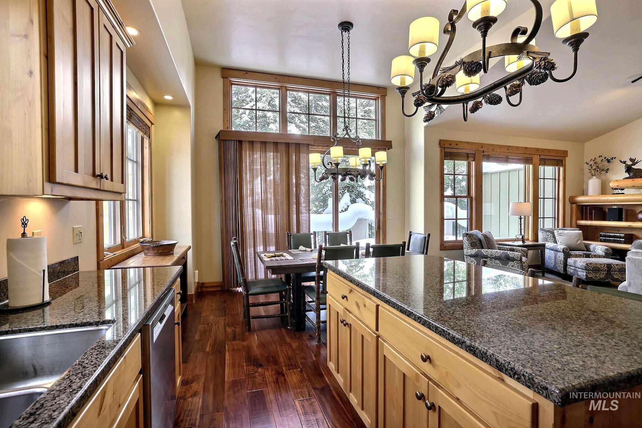 Kitchen with a chandelier, pendant lighting, healthy amount of natural light, dark wood finished floors, and recessed lighting