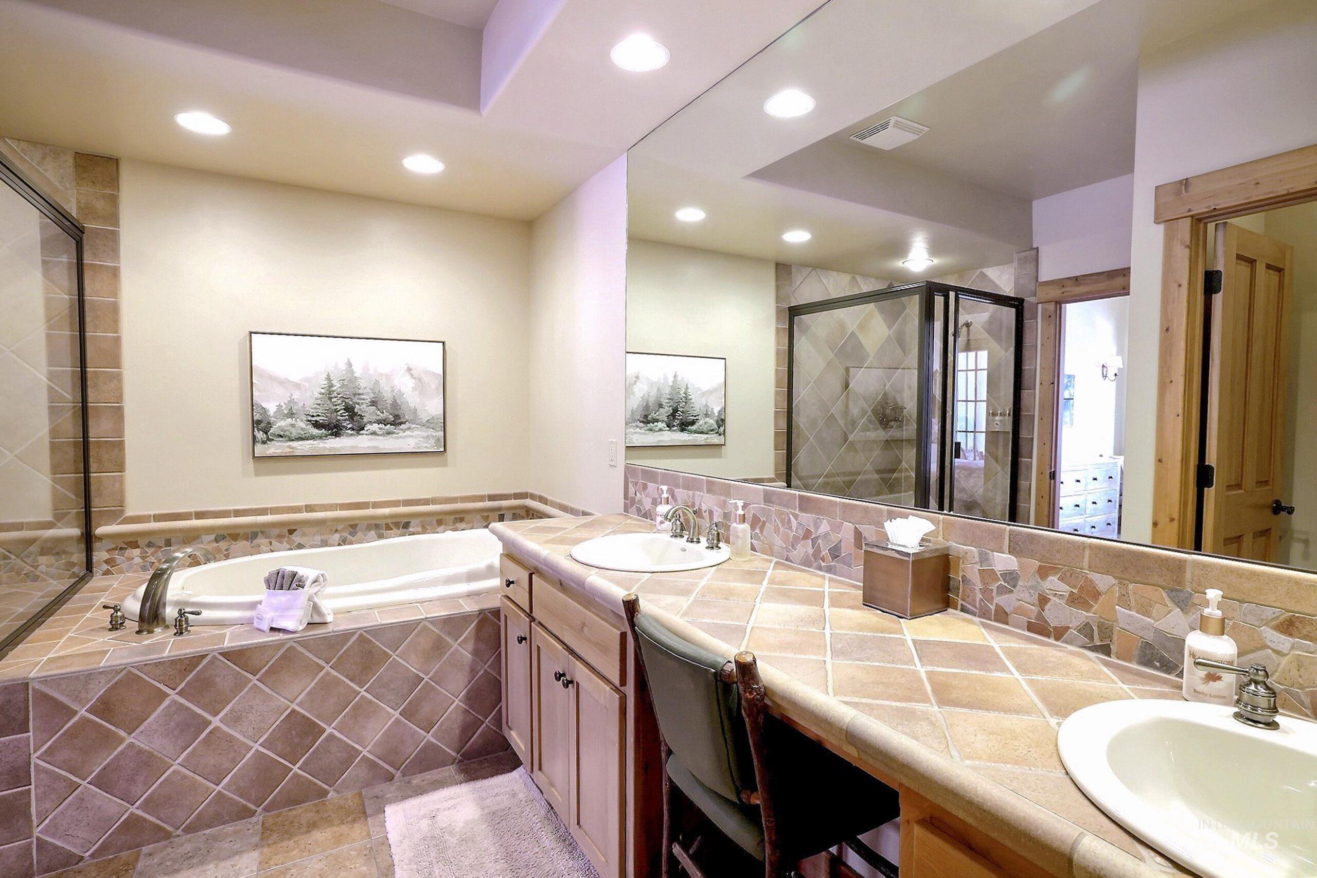 Full bathroom featuring a shower stall, a garden tub, double vanity, recessed lighting, and tasteful backsplash