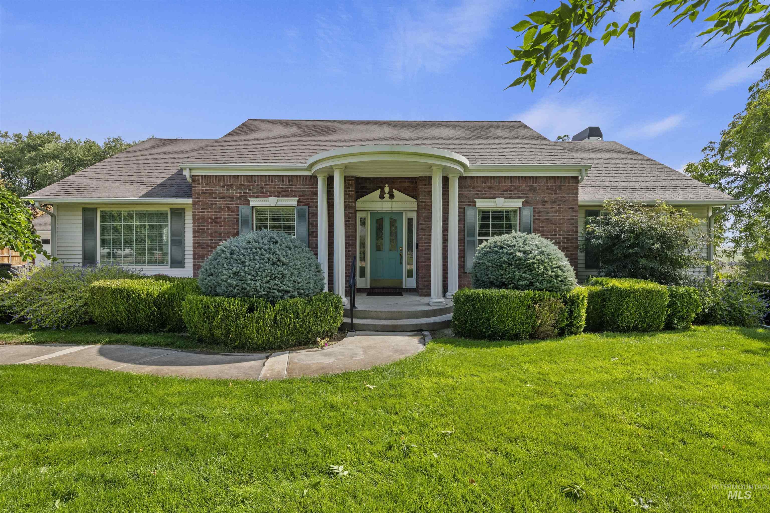 View of front of house featuring roof with shingles, a front lawn, and brick siding