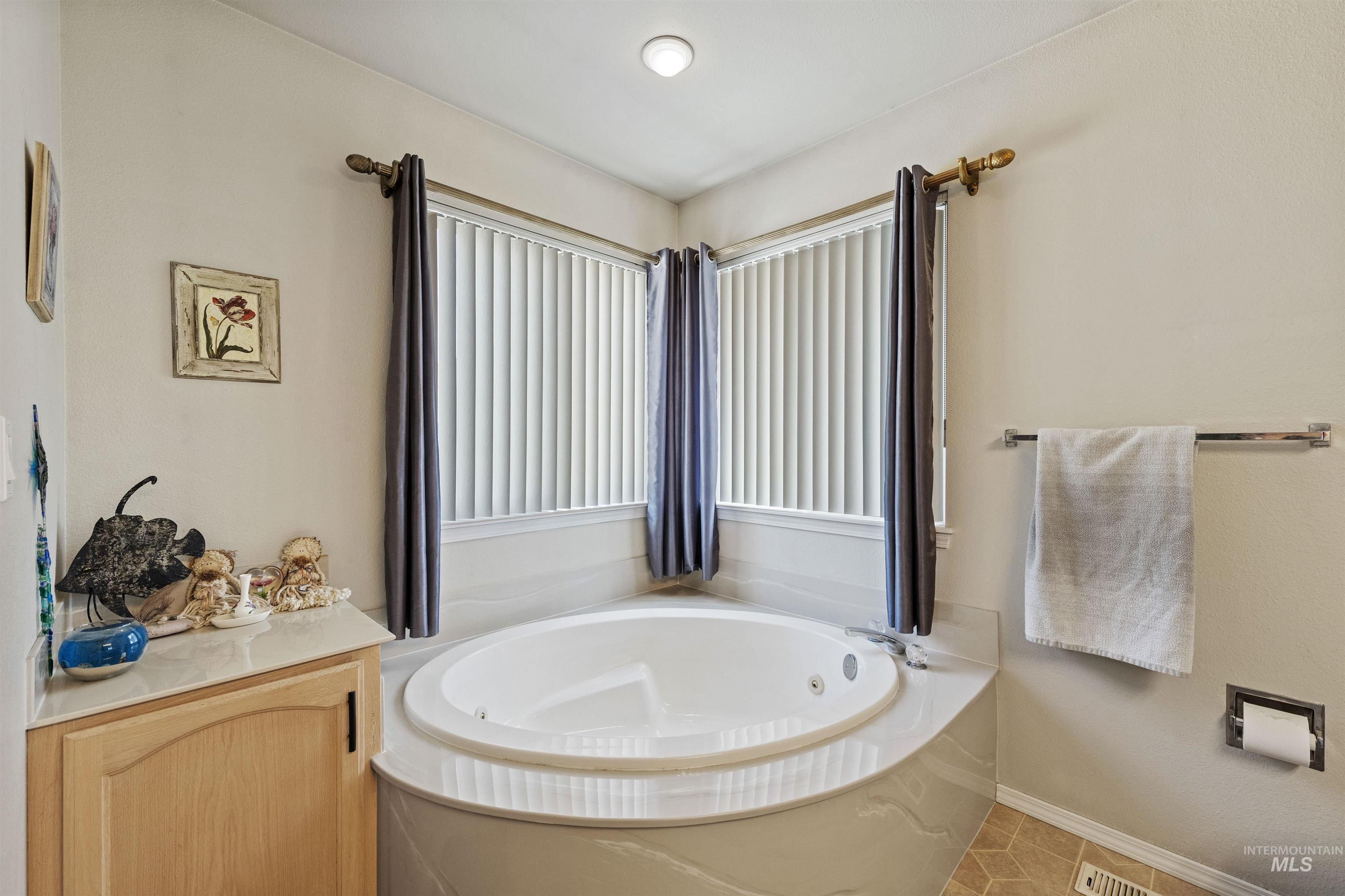 Full bathroom with a whirlpool tub and light tile patterned floors