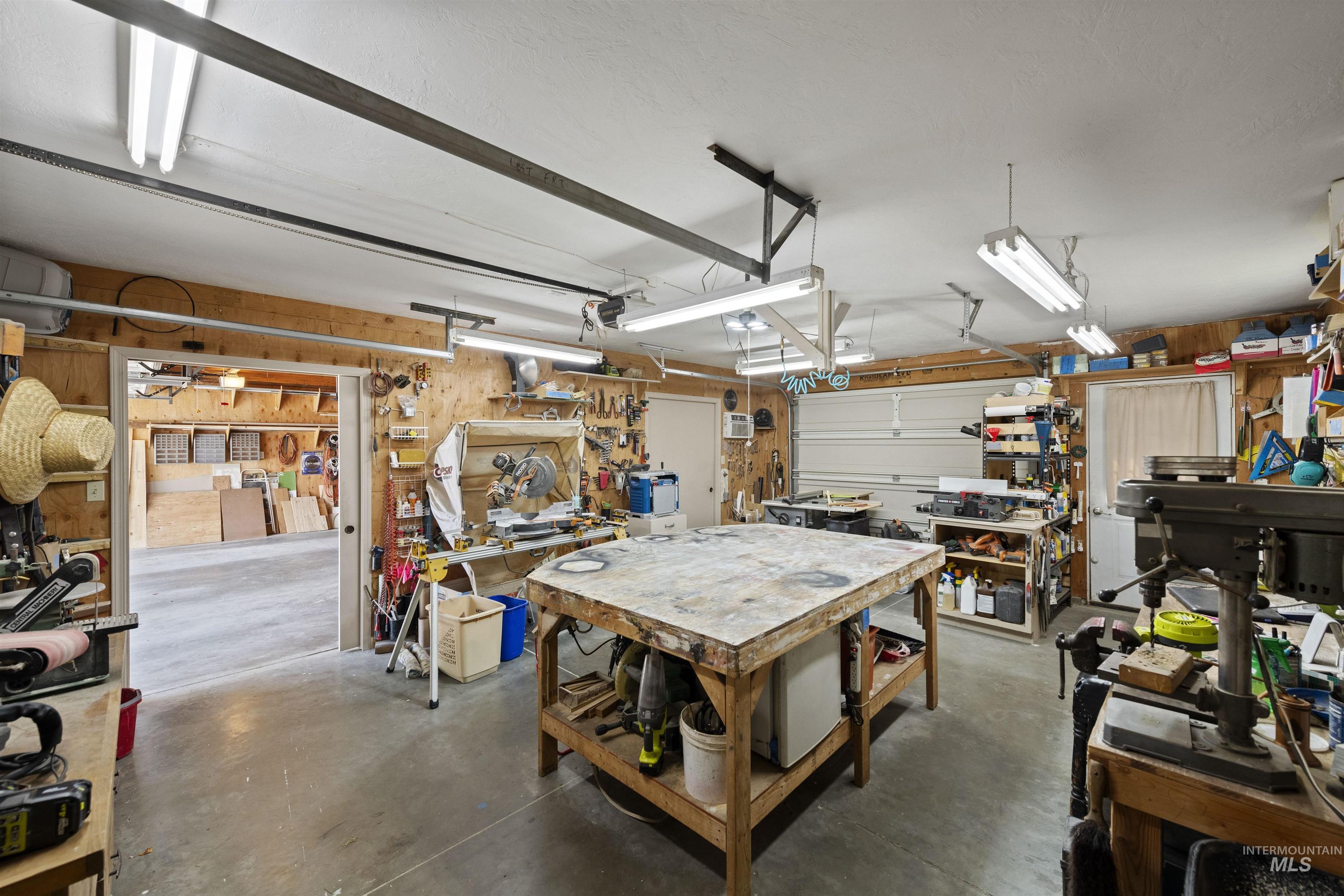 Garage with a workshop area and wooden walls