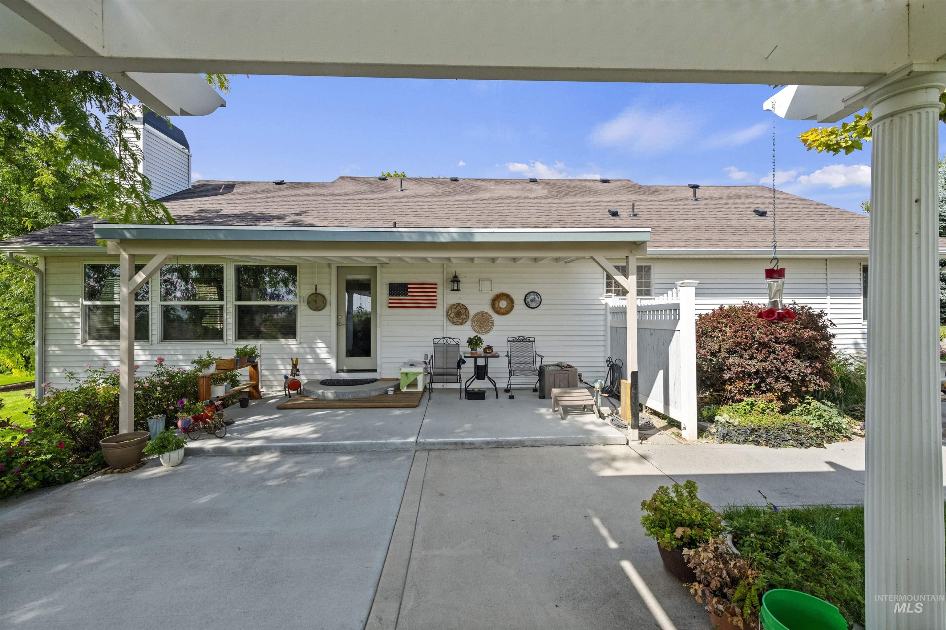 Rear view of property featuring a shingled roof, a patio, and a chimney