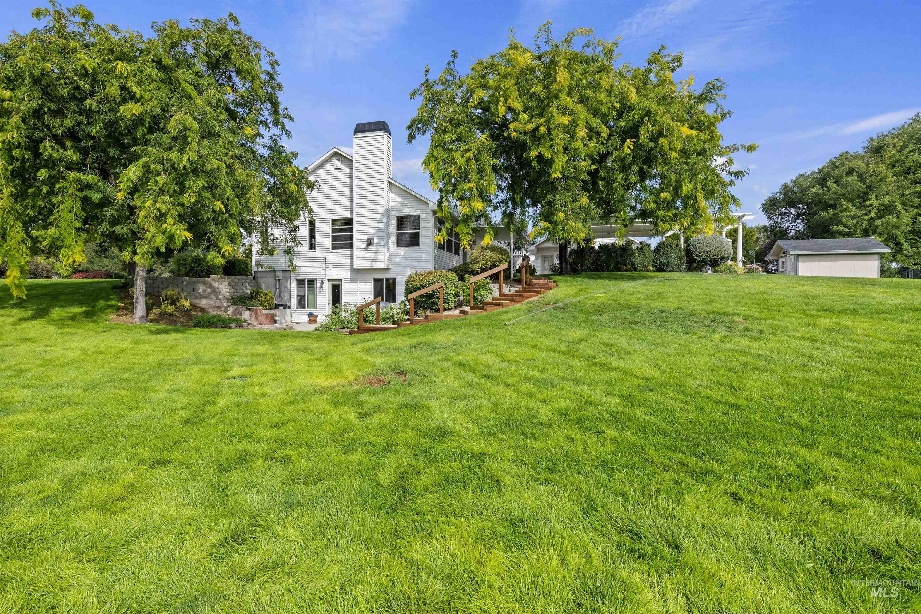 View of green lawn with a patio and stairway