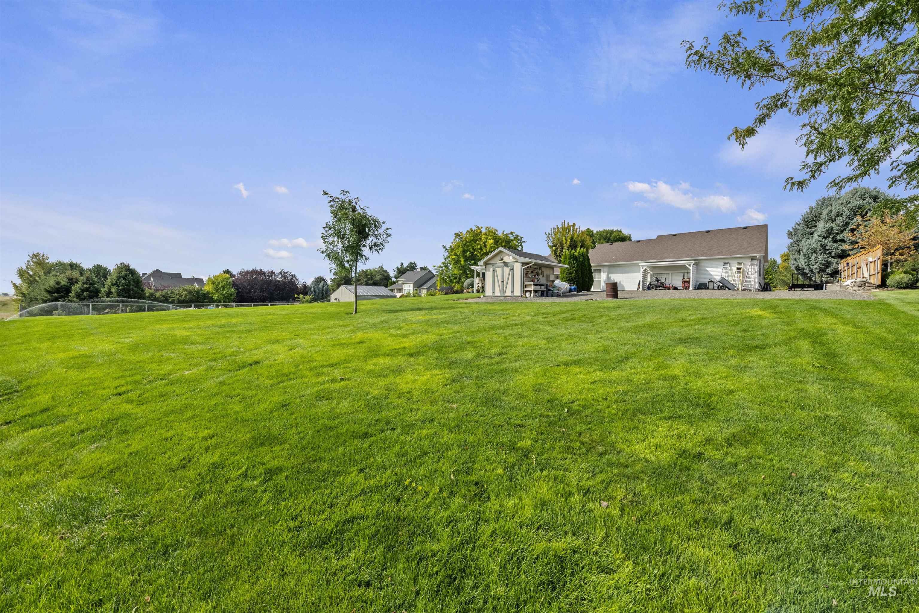View of green lawn featuring a garage