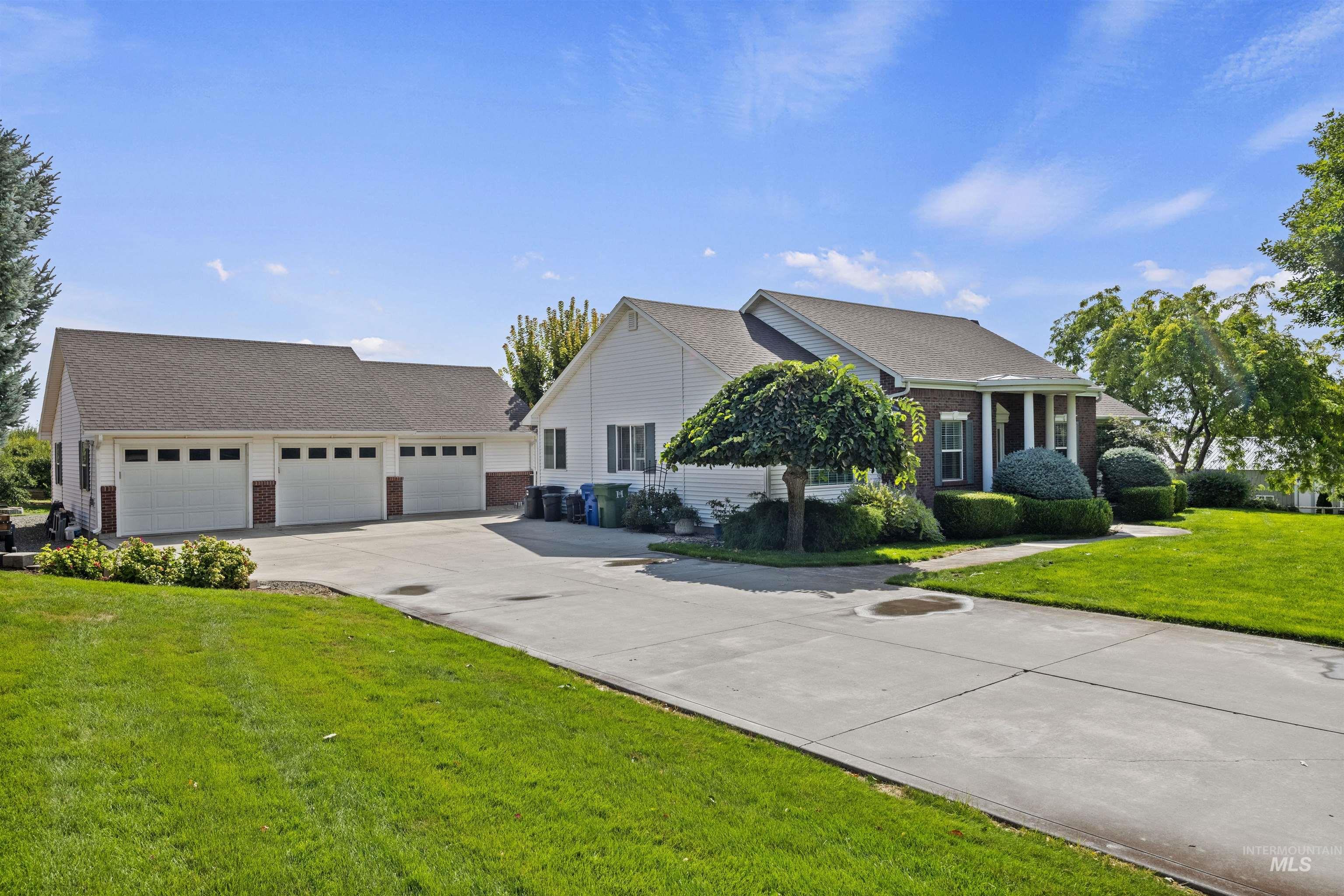 Ranch-style house with a front lawn, brick siding, and driveway