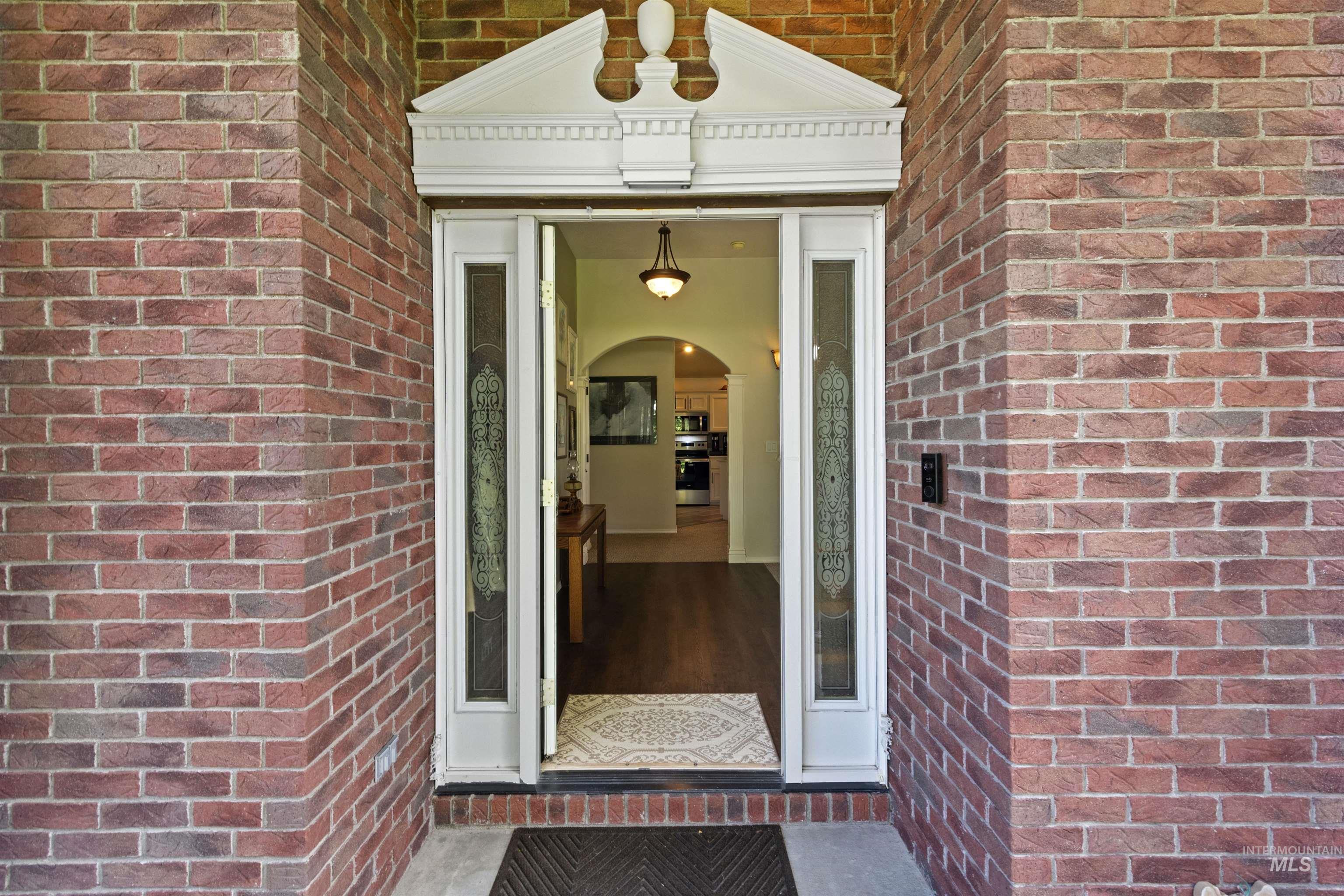 View of exterior entry with brick siding