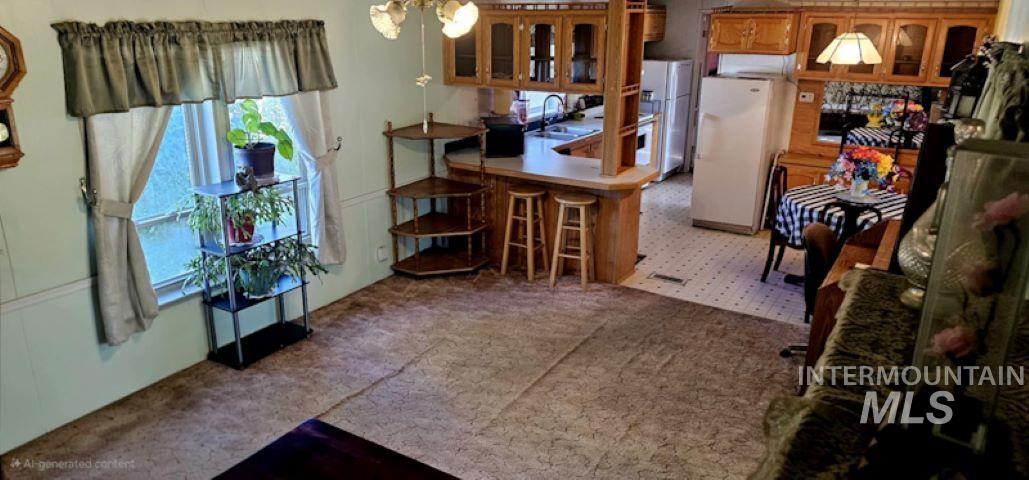 Kitchen with glass insert cabinets, freestanding refrigerator, brown cabinets, and a peninsula