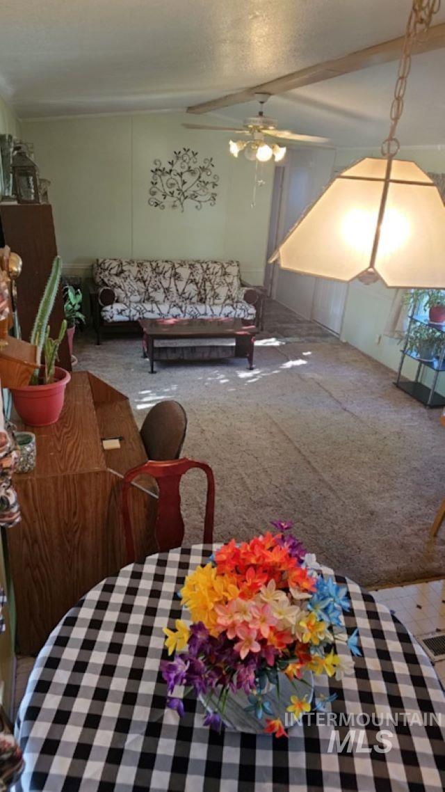 Carpeted living area with a ceiling fan
