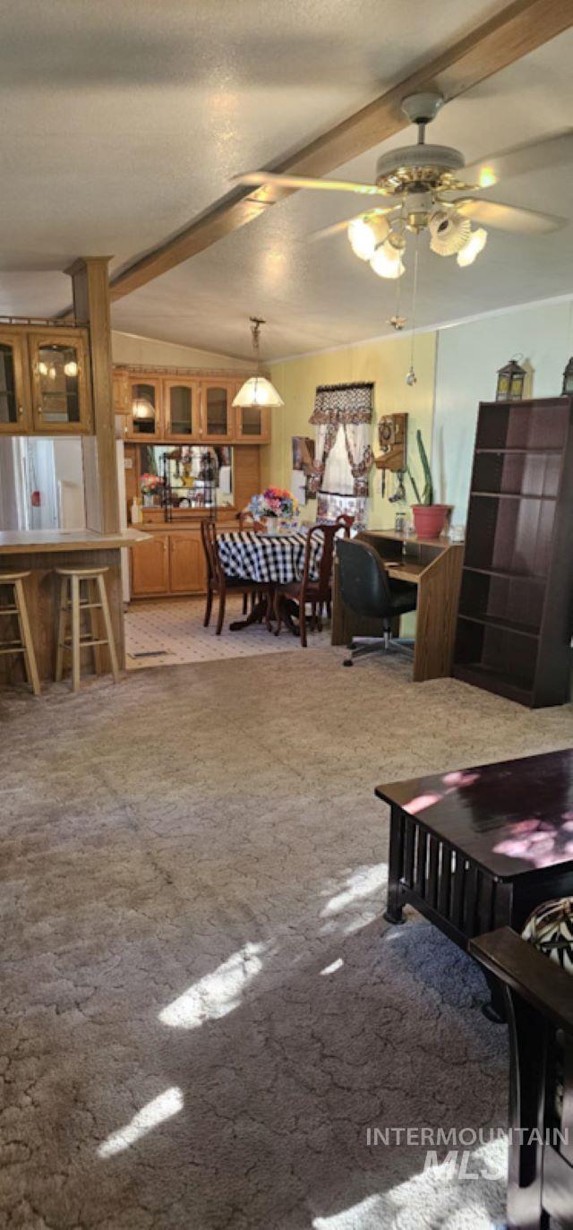 Living area with light colored carpet, a textured ceiling, and ceiling fan