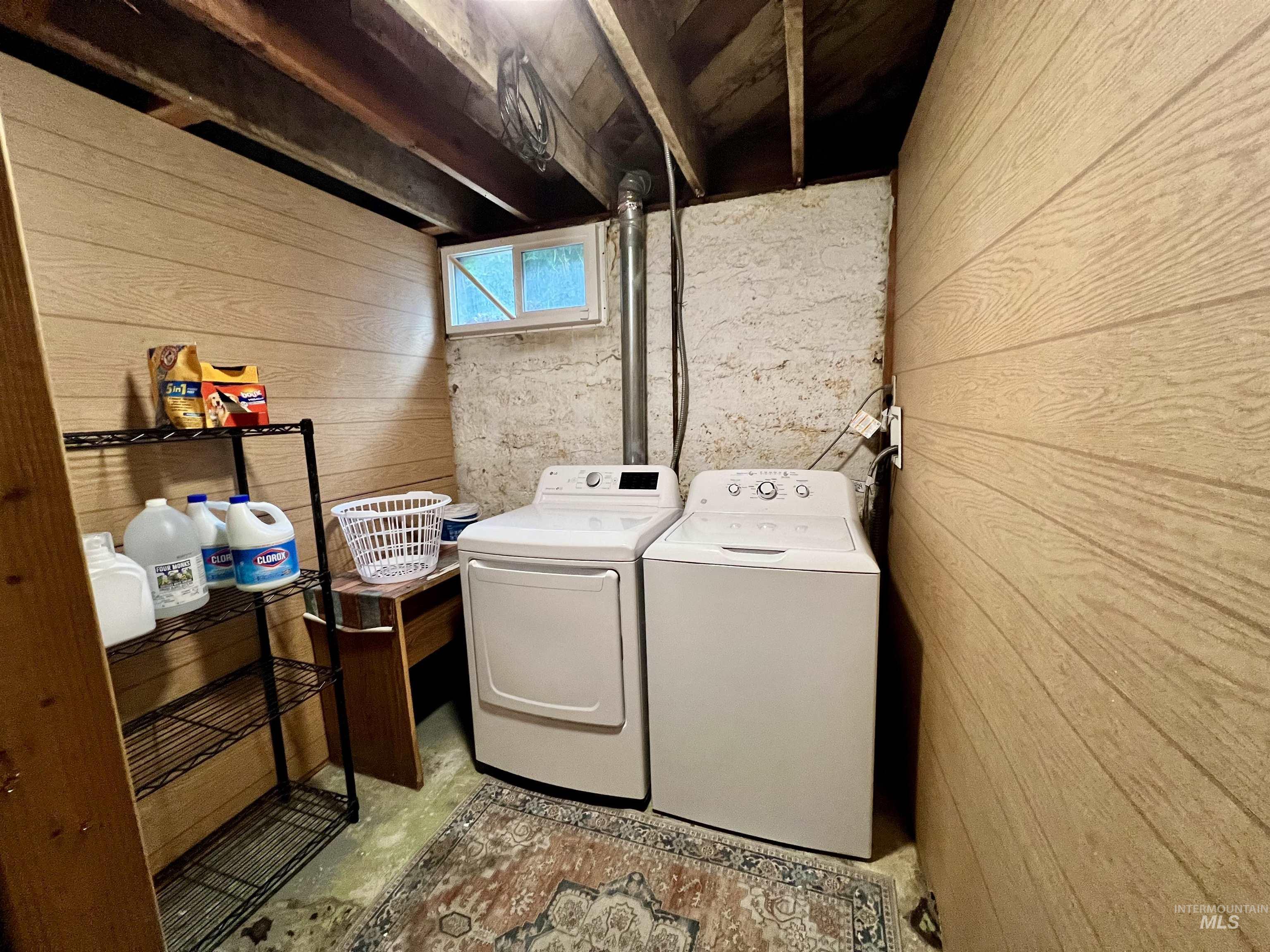 Laundry area featuring wood walls and washing machine and dryer